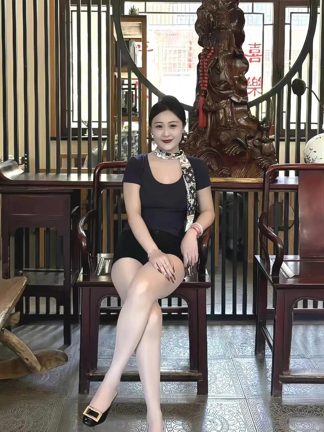 这位女士坐在古色古香的椅子上。