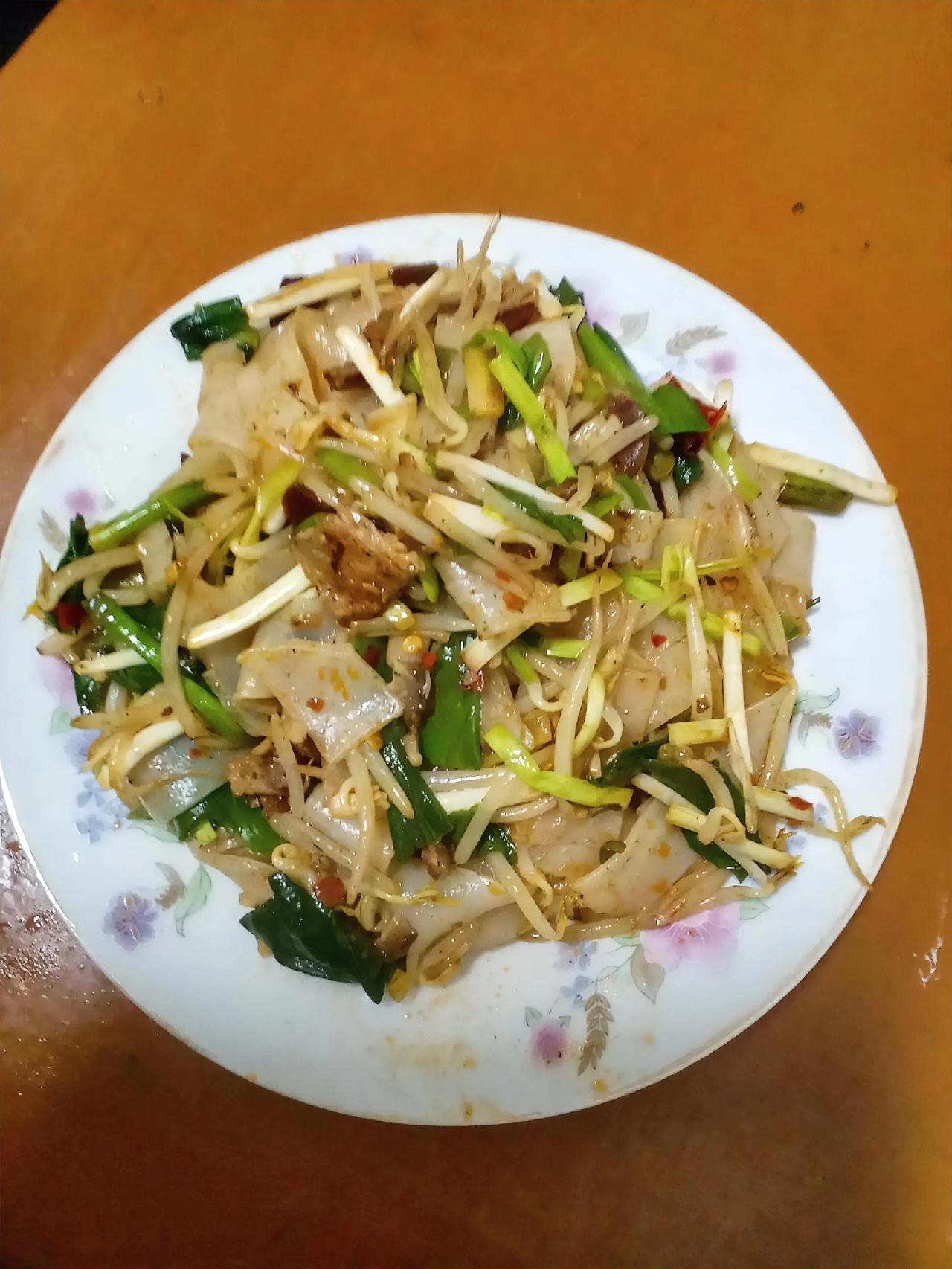 这盘家常炒米皮，藏着最踏实的烟火气。米皮筋道弹牙，豆芽脆嫩爽口，蒜苗和辣椒的辛香