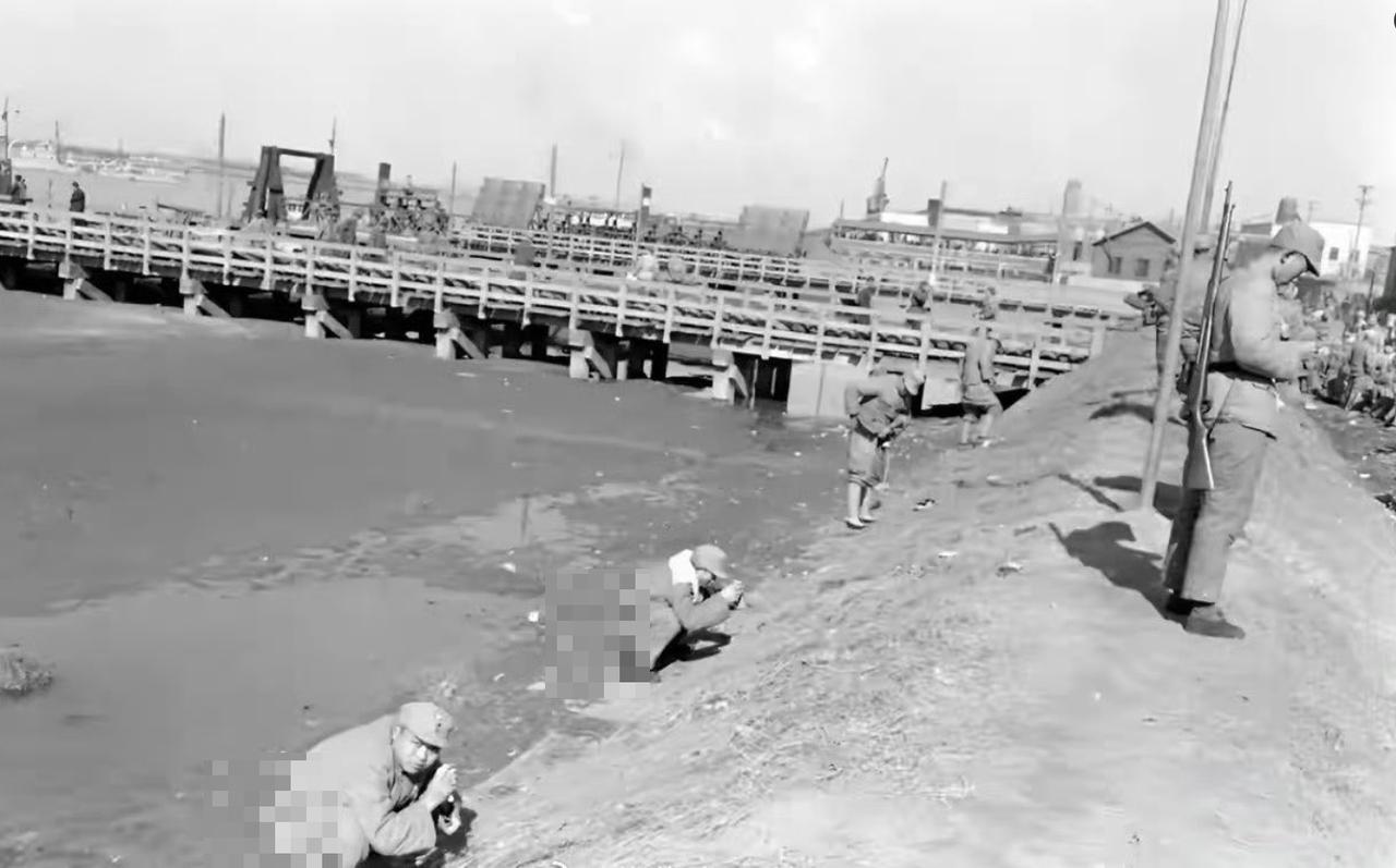 法国摄影家布列松拍的在1949年初的南京，国军撤退前，几名士兵蹲在秦淮河边解手。