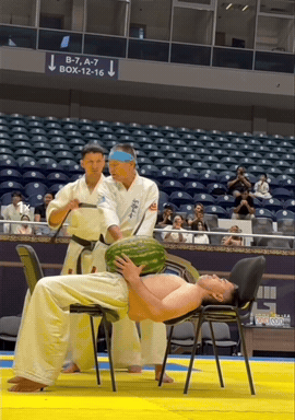 这年头才艺表演都这么拼吗？两把椅子架起人体案板，肚子稳稳托住西瓜，师傅还蒙上眼睛