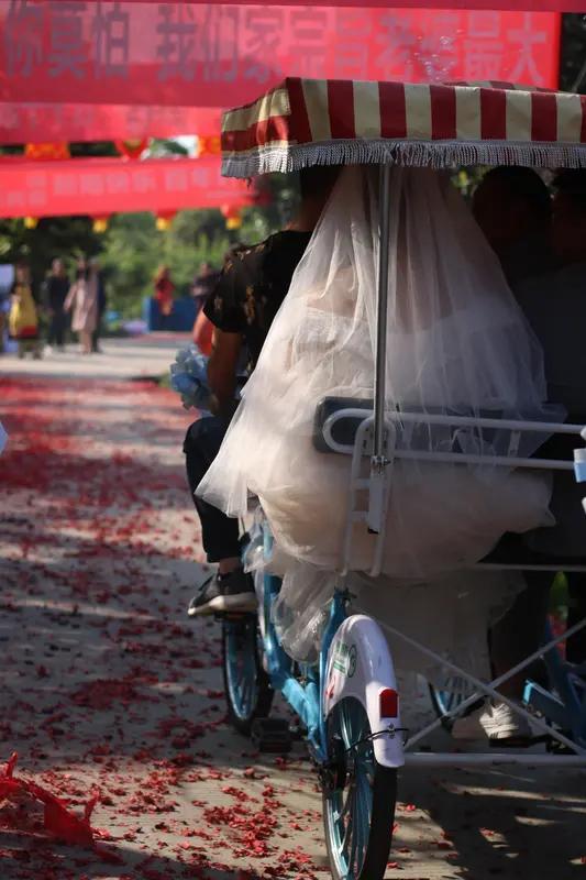 00后新婚夫妻用摇摇车接亲太有创意了！3月31日消息，安徽宿州这对从事婚庆行业的