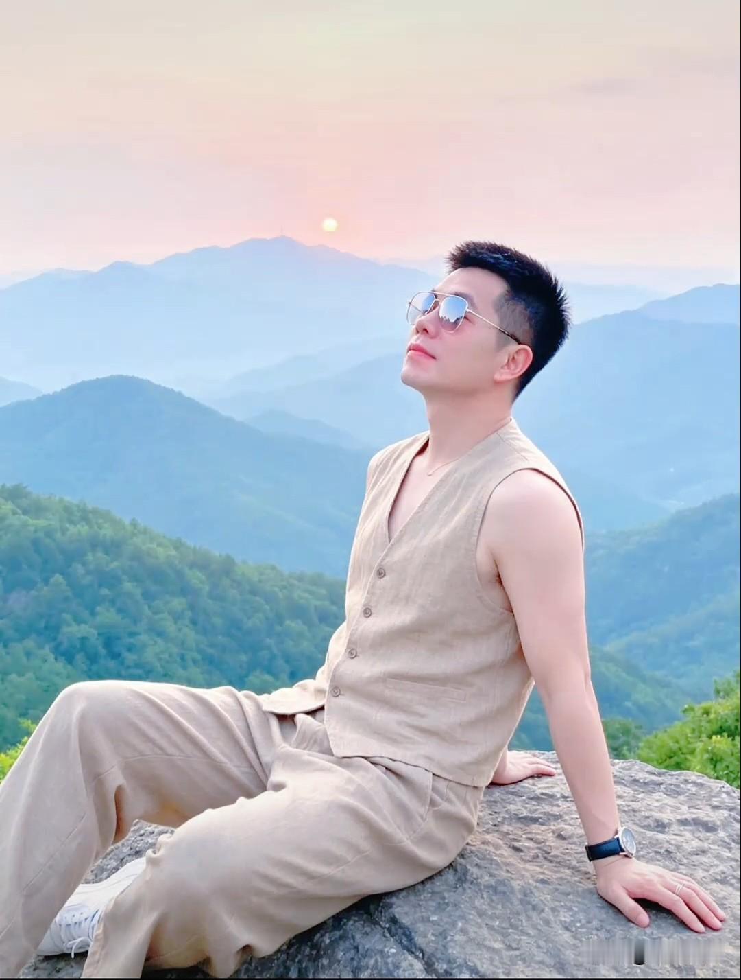 坐在山顶巨石上，看层峦叠嶂染上粉紫霞光，夕阳悬于远山之巅，风里都是自由的味道。一