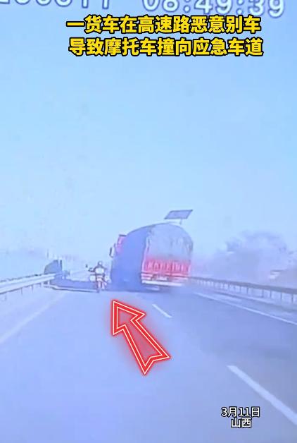 货车恶意别车致摩托车撞向应急车道，看视频可以看得出来，第一次货车司机就别了一下摩