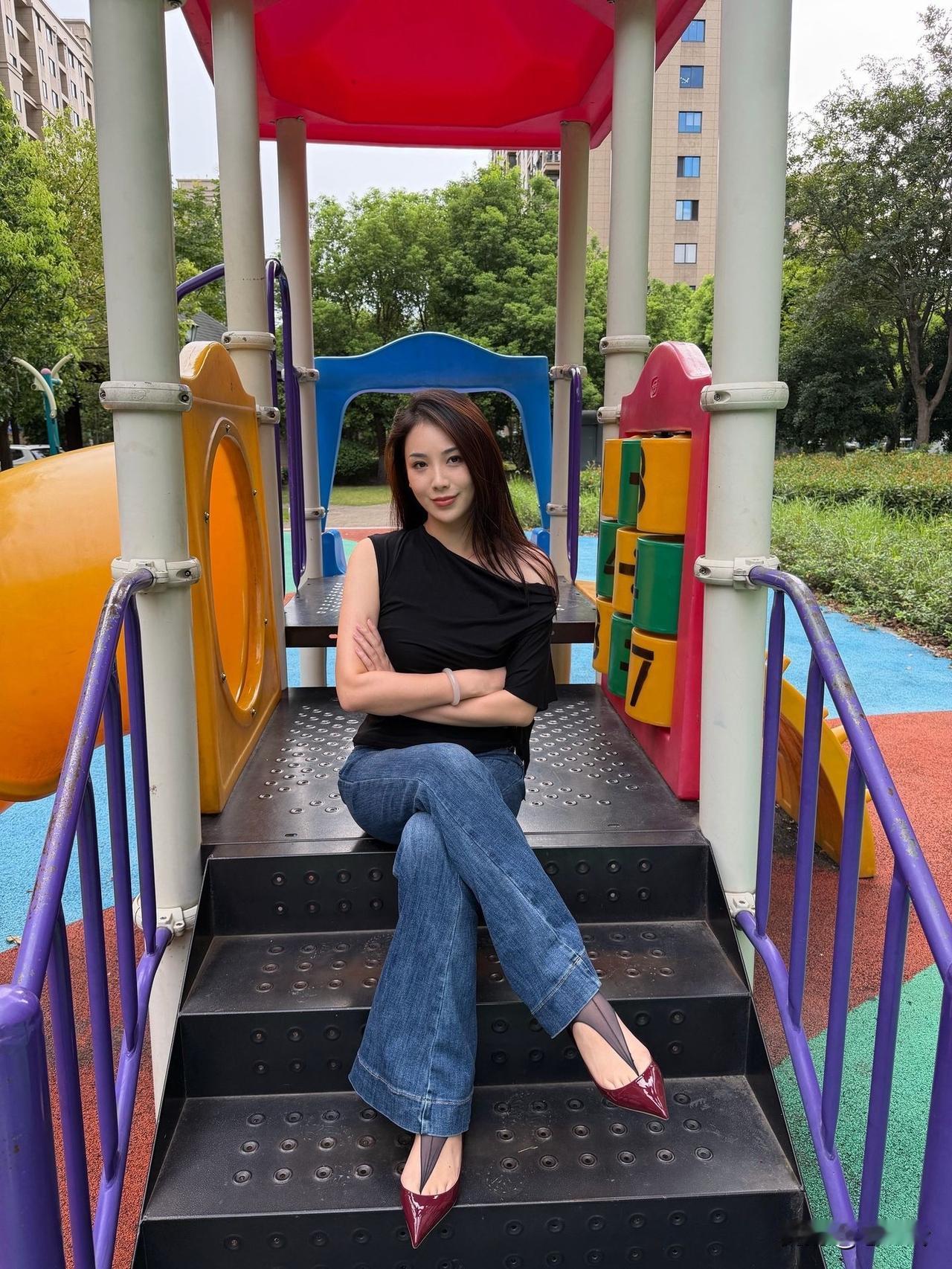 一位美女坐在游乐场的台阶上。