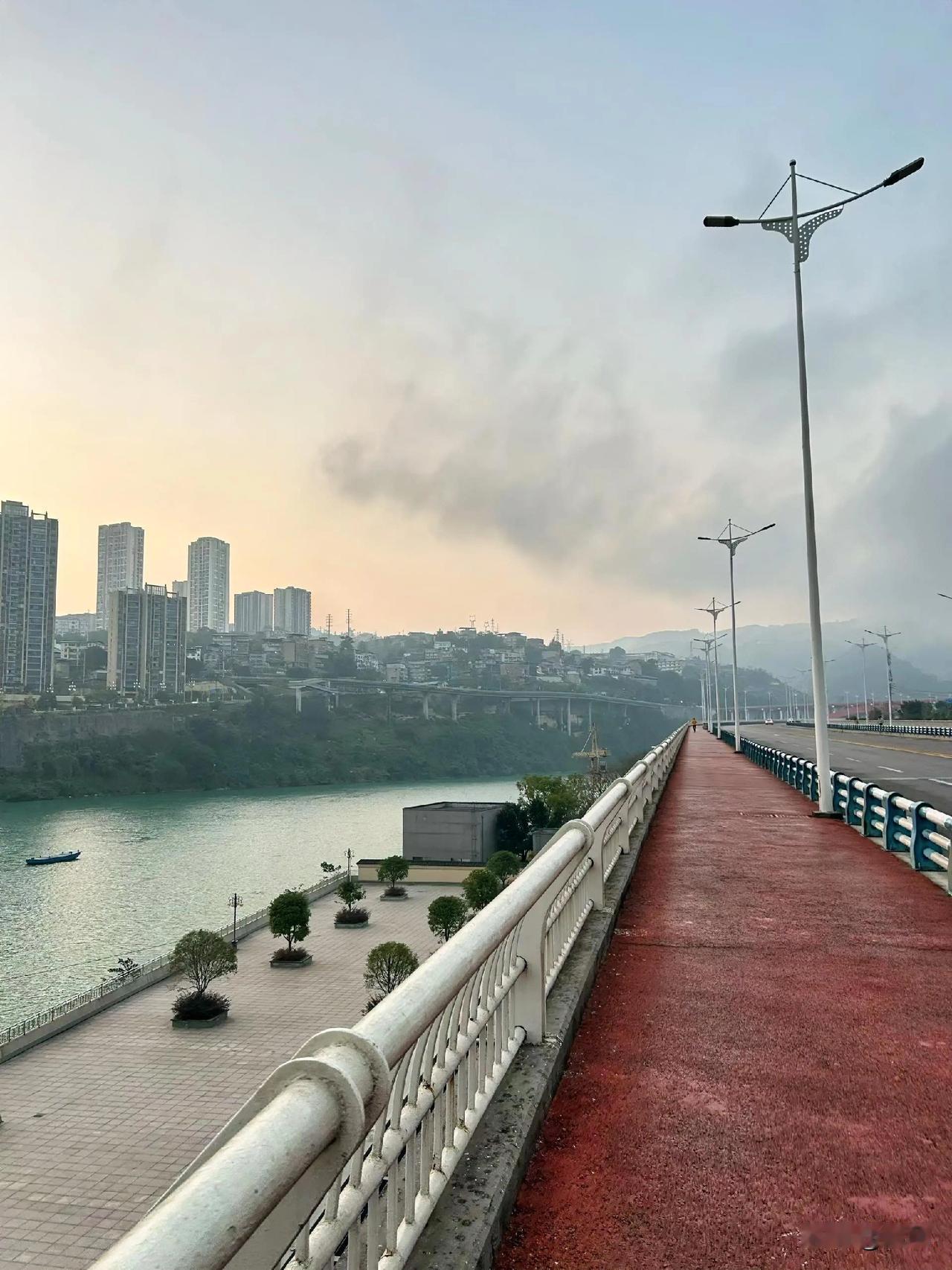 站在这座桥上，江风裹着清晨的凉意扑过来，视线顺着红色的步道往前伸，像要融进远处的