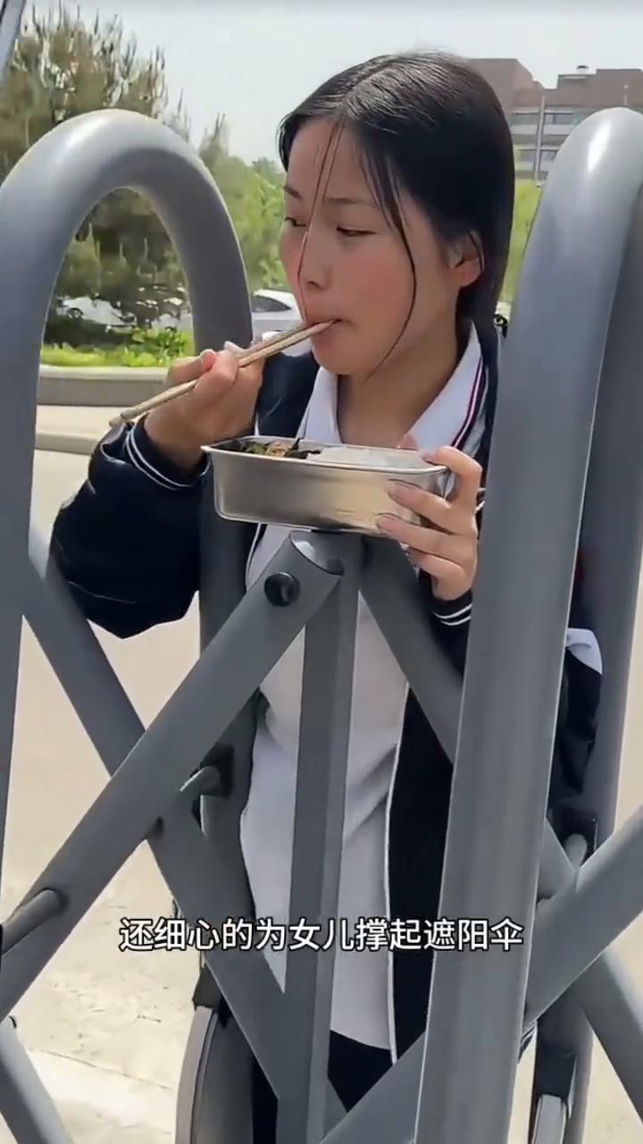 无声的父爱。
注意看，这位男子拎着衣服和饭菜来到学校门口，校内的女儿得知消息后立
