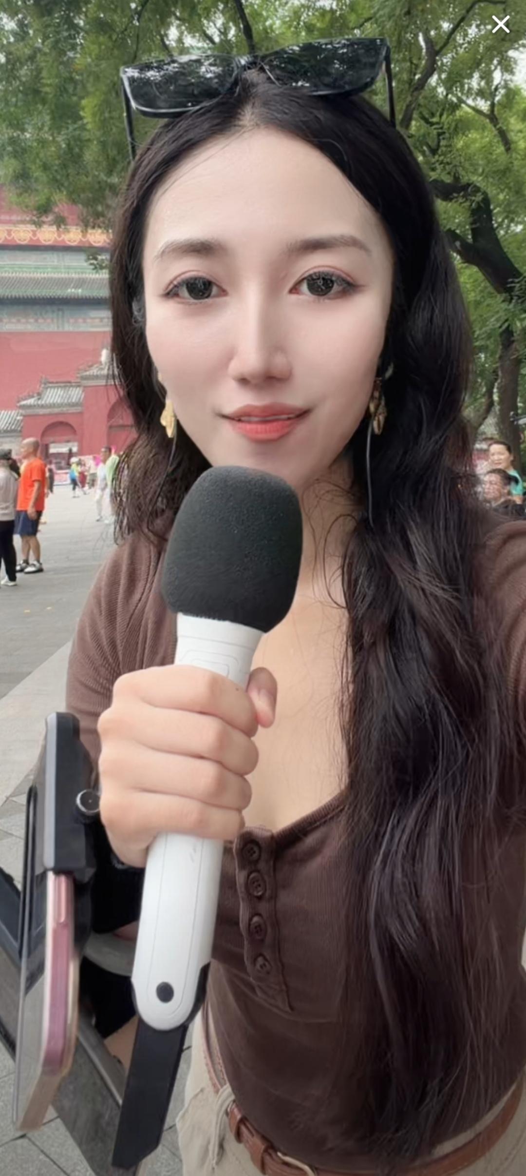 这姑娘拿着话筒，像是在采访。