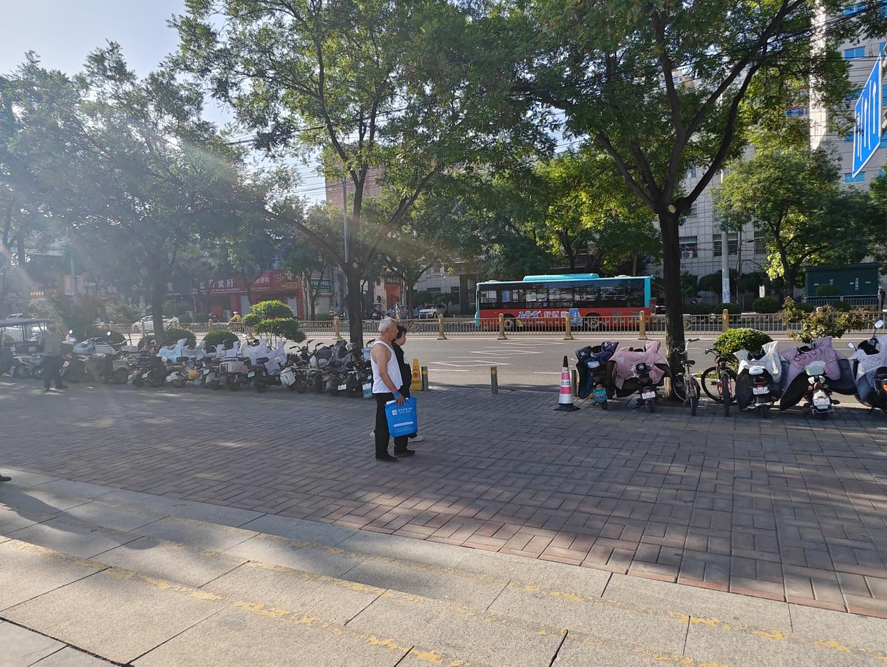 在运城盐湖西花园门口，我又被这对老年夫妻给温暖到了。

这对老年夫妻手牵手，侧面
