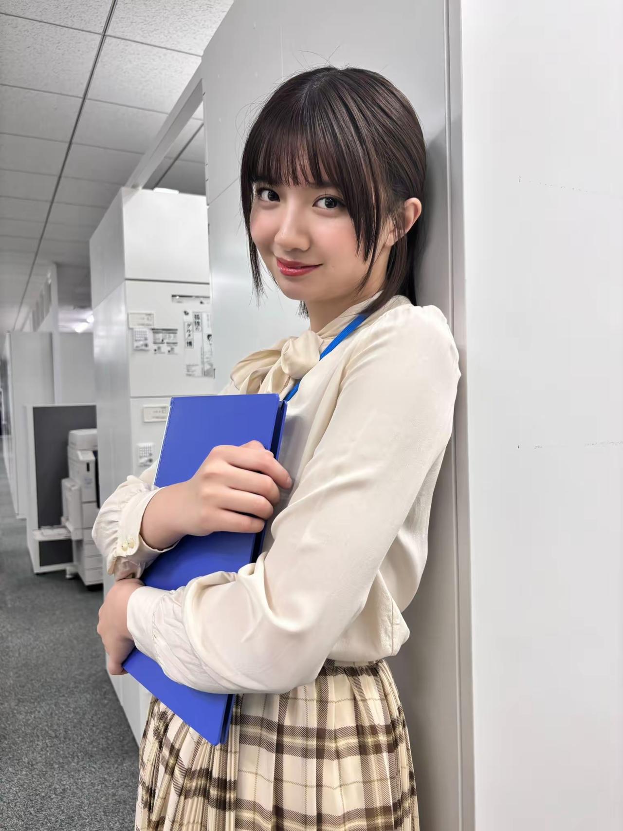办公室小可爱，手持蓝色文件夹，微笑面对镜头