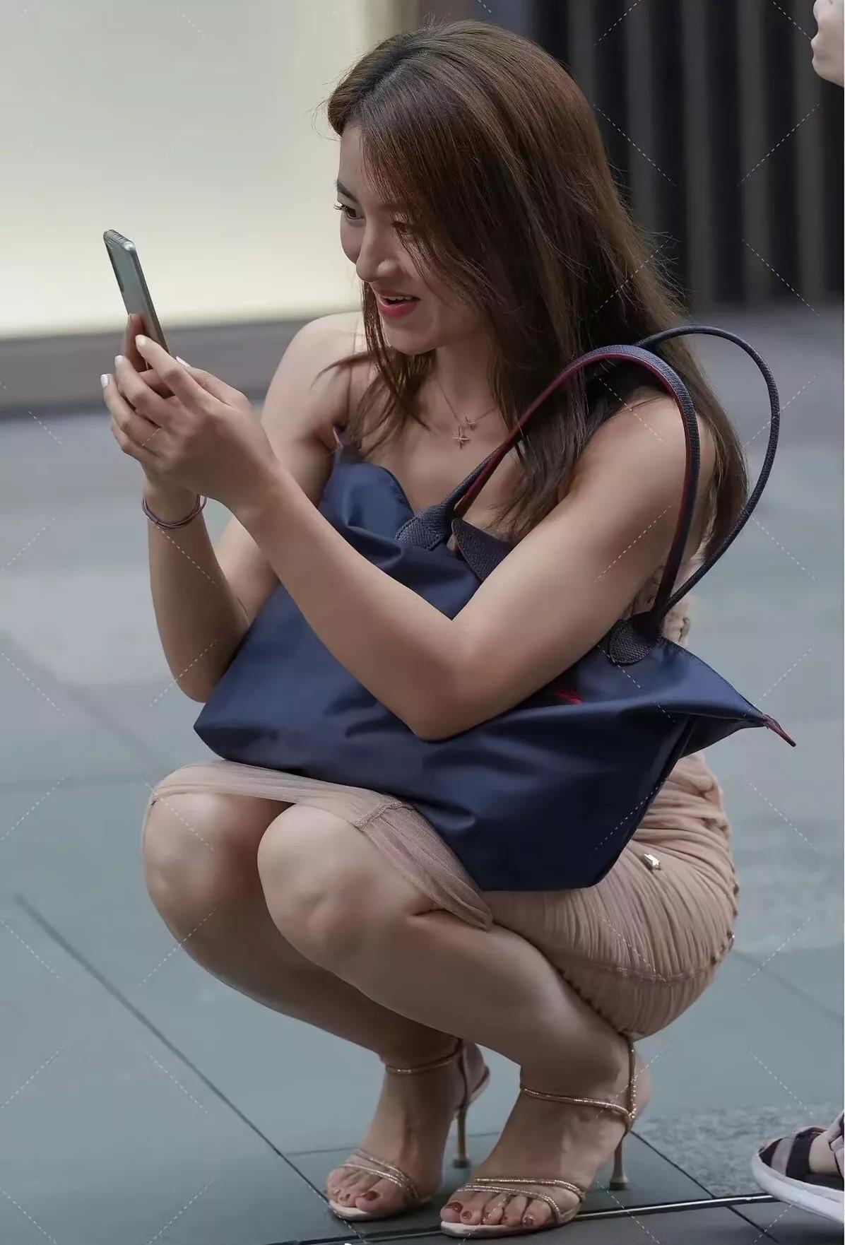 前方地上究竟有什么东西，引得这位小姐姐非要蹲下身子拍照呢？瞧她脸上洋溢的笑意，想