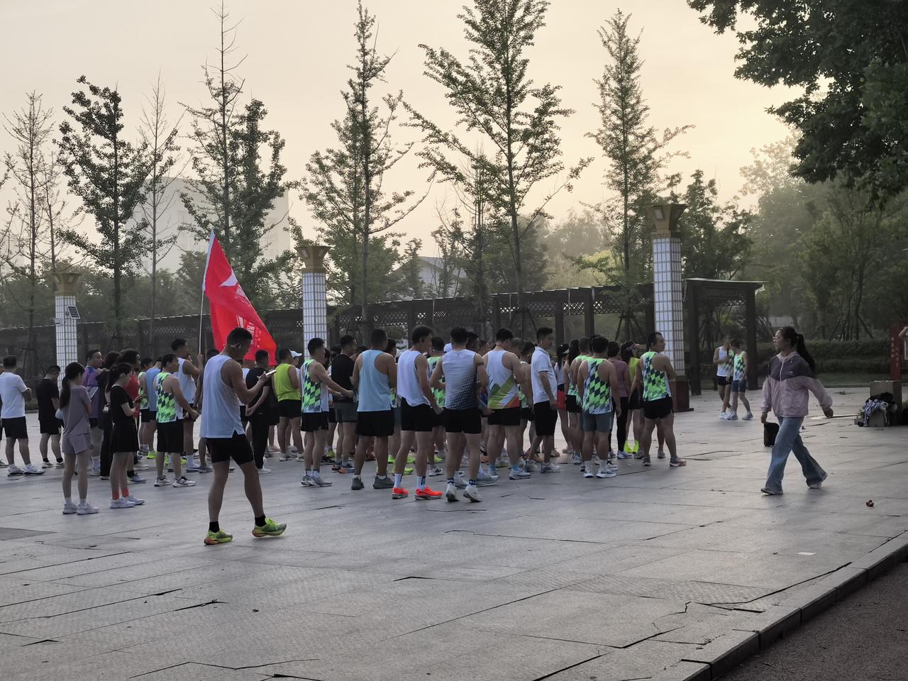端午假期，鄢陵跑步协会几十个人，在花博公园北广场列队聚集。他们的旗帜迎风招展，似