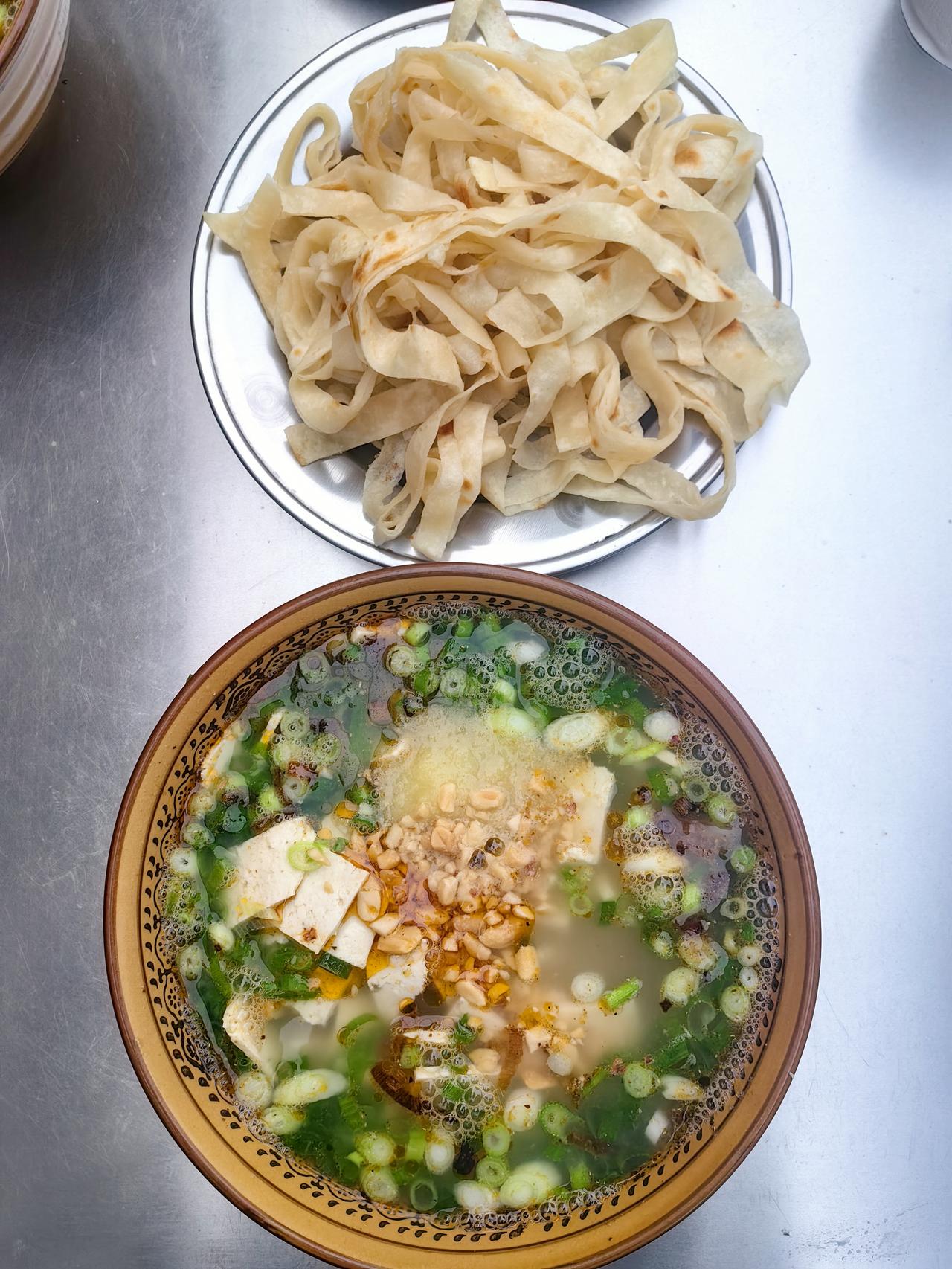 豆腐汤泡饼丝
 
清晨的巷口飘着淡白热气
一碗嫩豆腐卧在清汤里
葱花浮着细碎的香