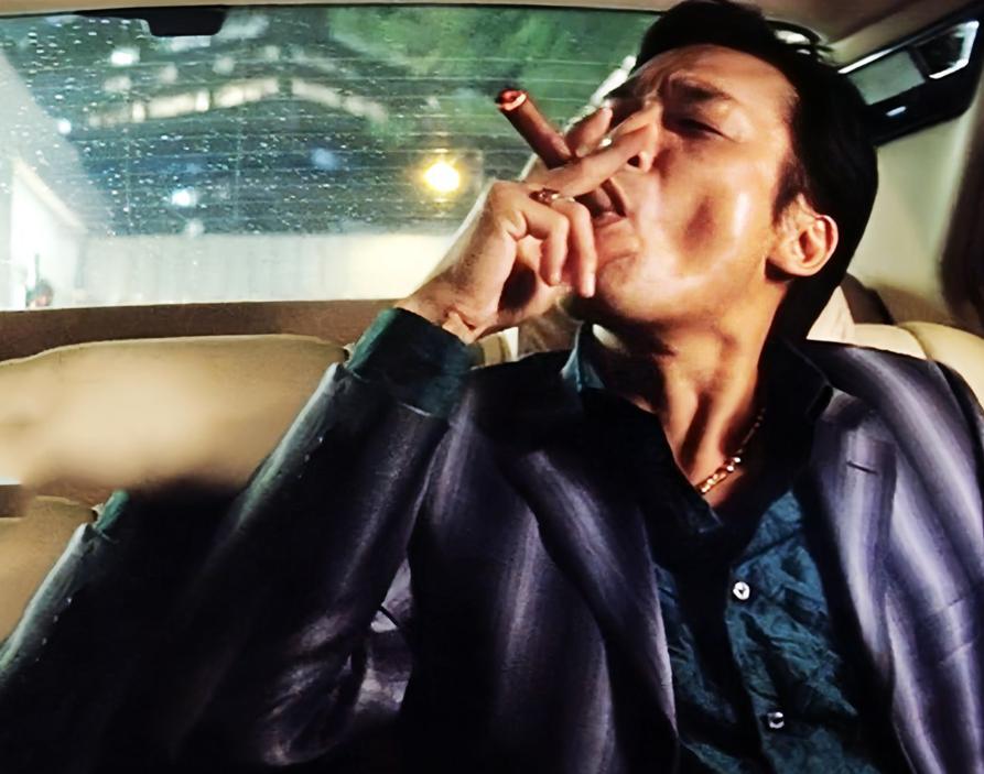 当年“天上人间”的老板覃辉开车在路边跟一辆老旧轿车发生剐蹭，嚣张惯了的他下车就冲