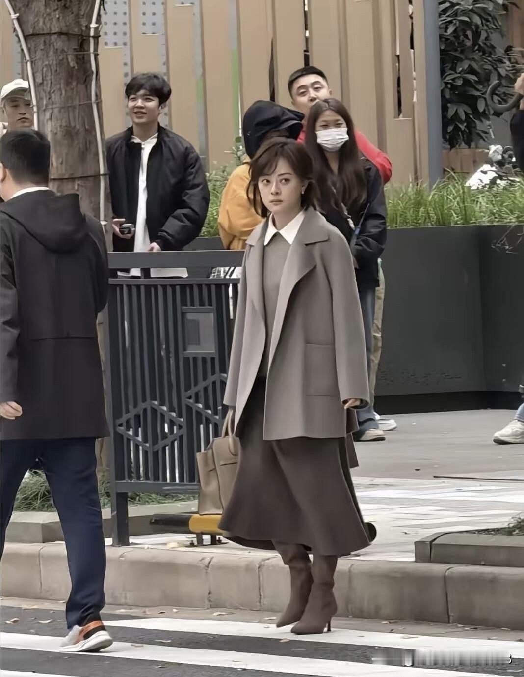 她年轻的时候是清纯、率真，现在年龄增长之后是成熟的魅力之美，本人站在马路边，个子