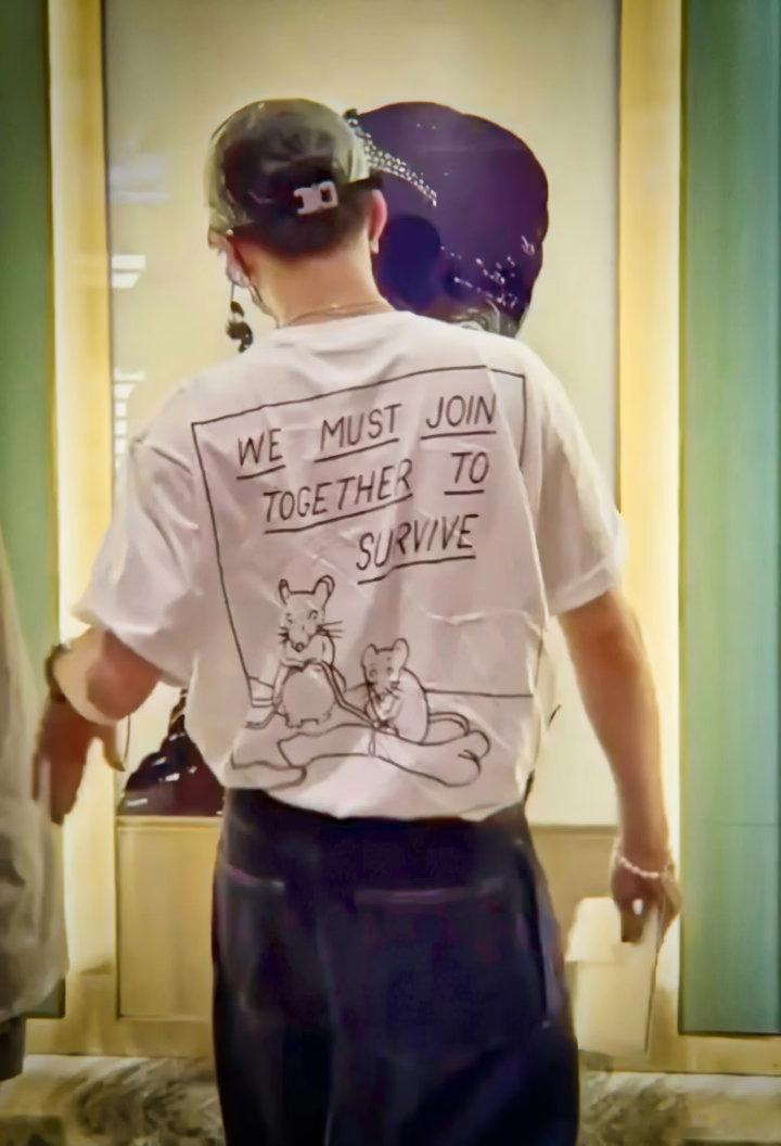21年河南暴雨 在机场穿的这件衣服的背面印的是WE MUST JOIN TOGE