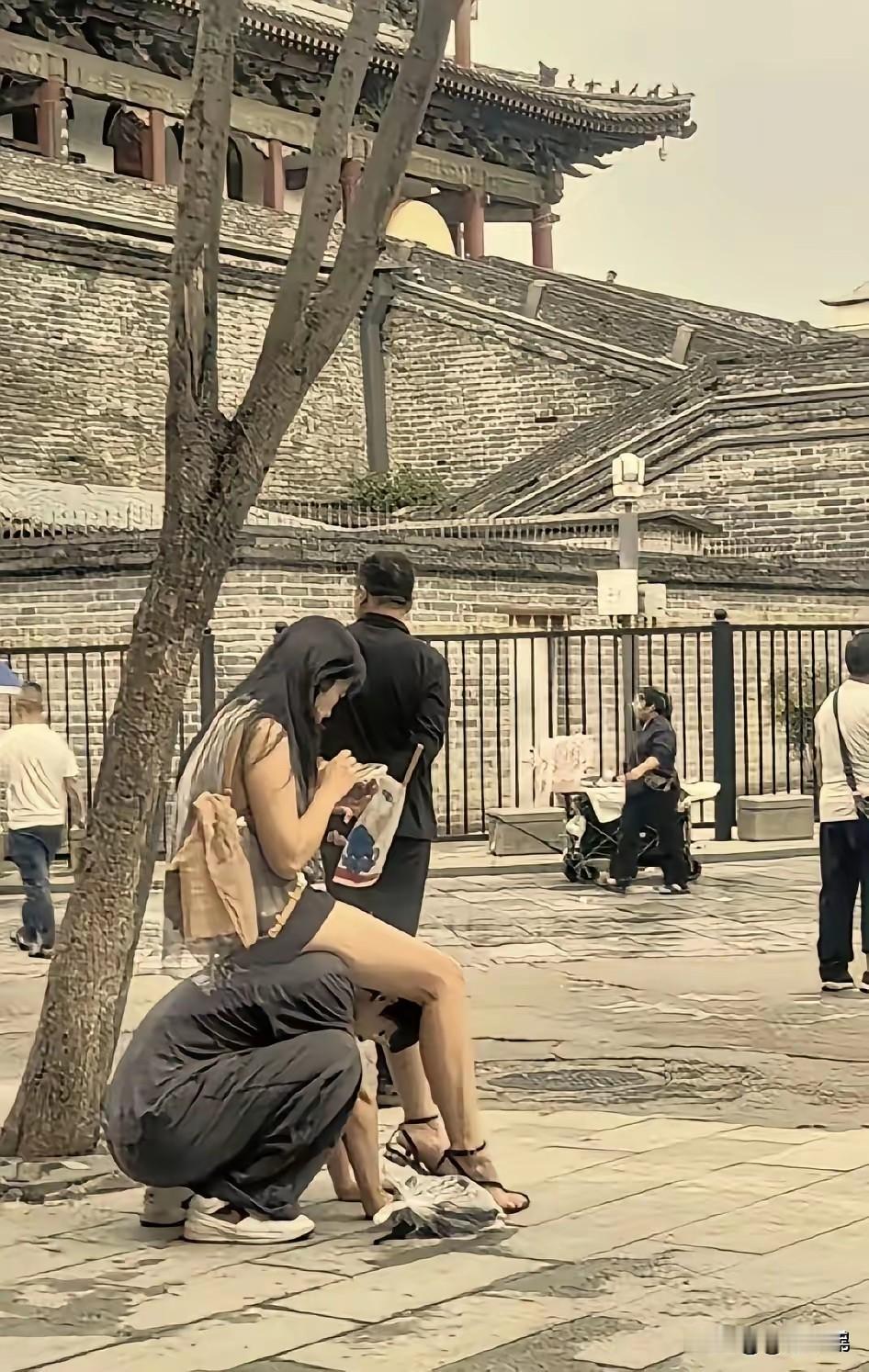 女朋友走累了，坐男朋友肩背休息，很好！

有人认为，这很可悲。

错！这不是可悲