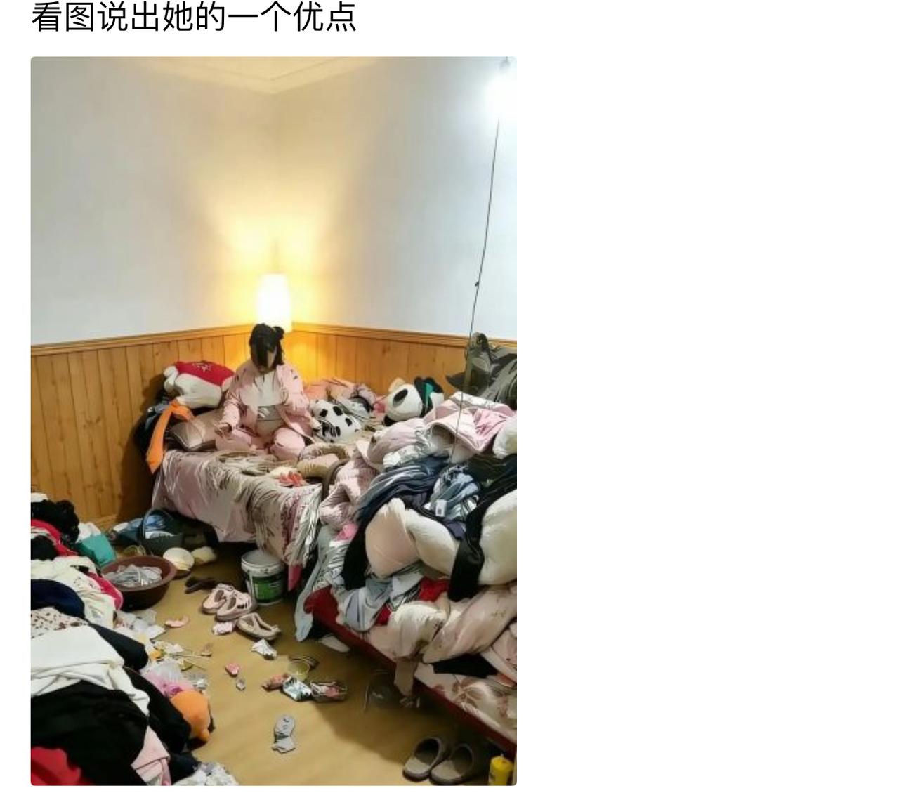 房间里衣物杂物堆得满满当当，地面几乎没多少落脚的地方，可她安安稳稳坐在床铺中央，