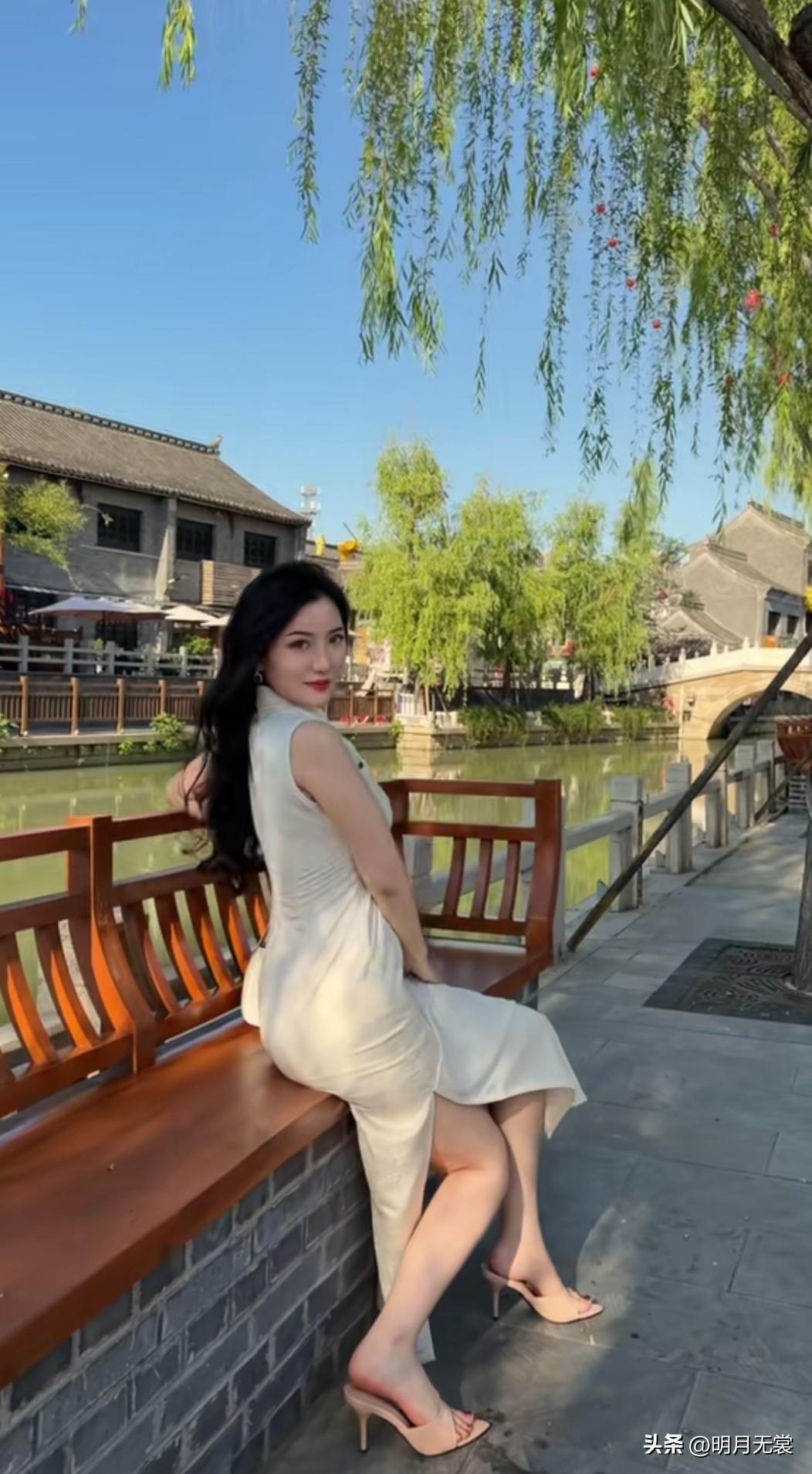 在古风小桥流水旁，优雅白裙与高跟鞋的完美搭配，尽显都市女性魅力。