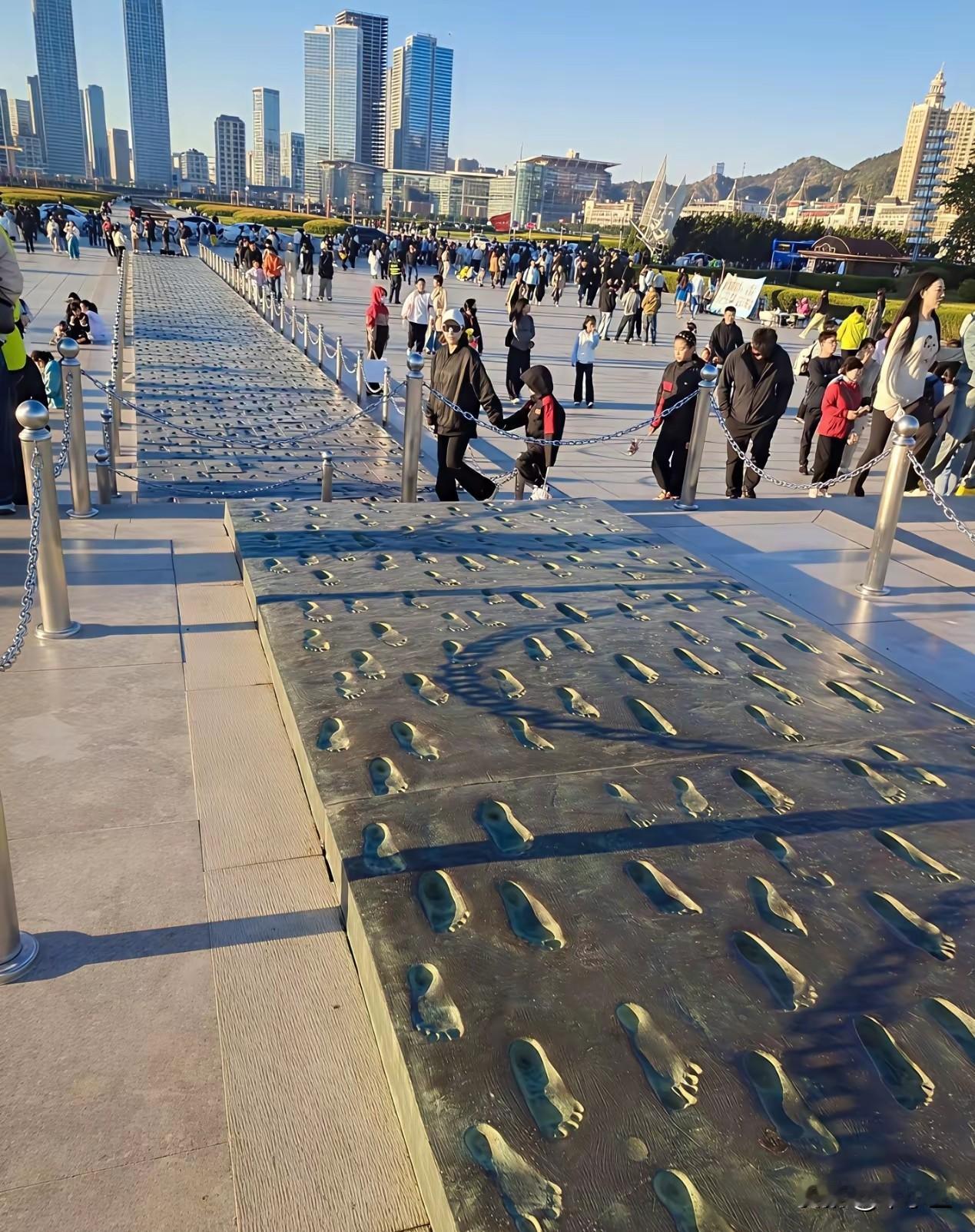 大连星海广场雕塑（铜制）脚印不让踩了，竖起的围杆，不知为什么大连标志