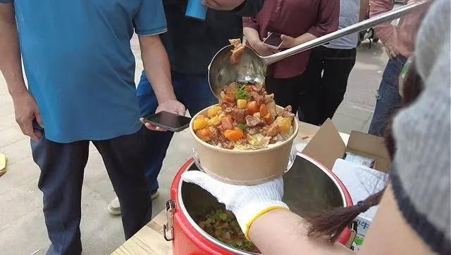 河南郑州一家肿瘤医院的门口，一位长相漂亮的女子正在摆摊卖盒饭。可奇怪的是，这位女