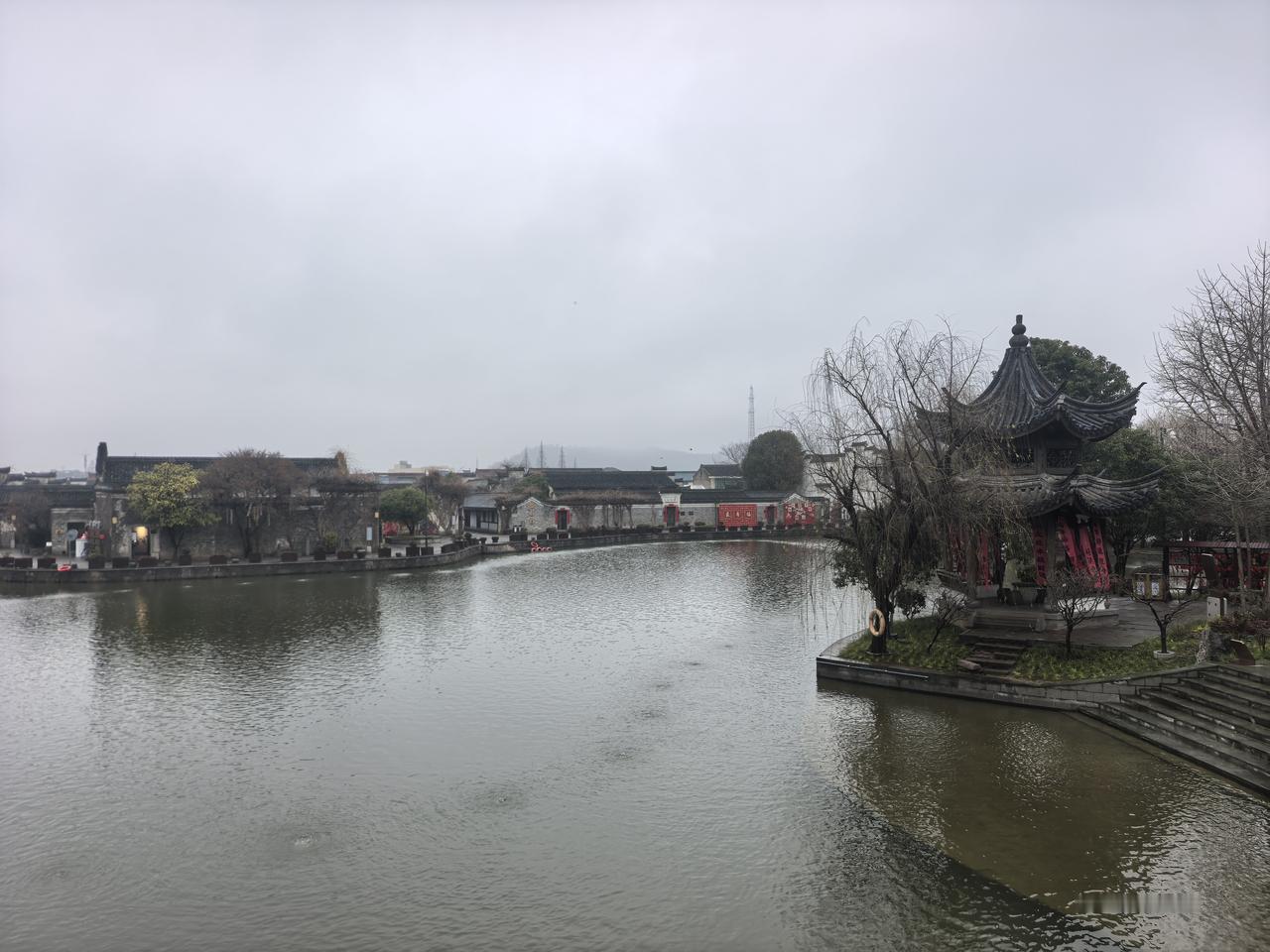 一场薄雨，把郑氏十七房晕成了一幅未干的水墨画。
青石板路被雨水浸得发亮，倒映着高