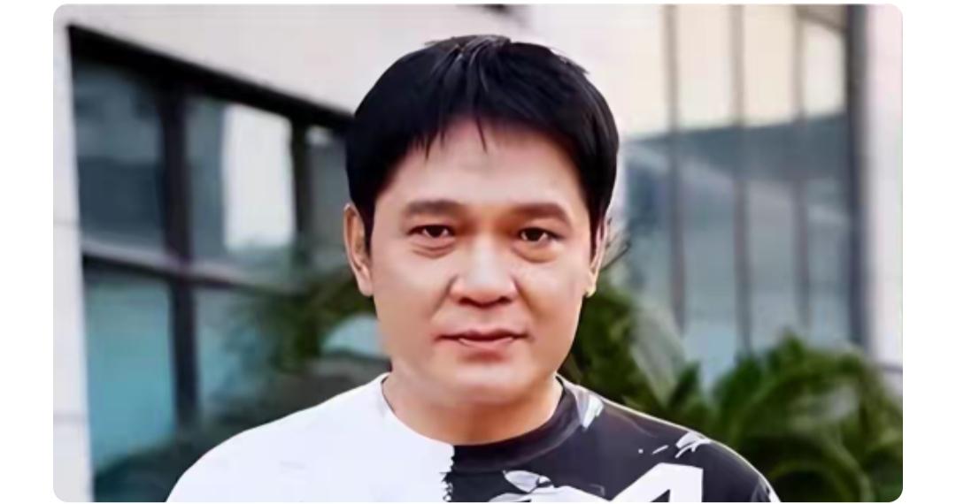 这位大哥穿着黑白拼色T恤。年轻的时候真帅，很多人不知道他的名字，但是绝对看过他的