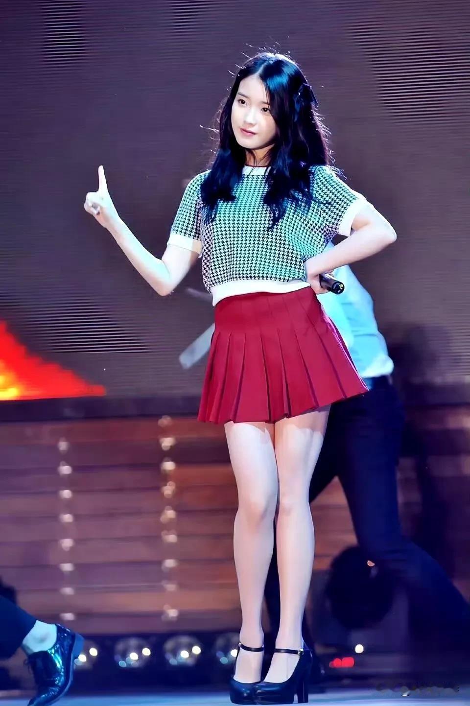 舞台上表演的李知恩，拥有甜美可人的外形，青丝如瀑的黑色微卷长发。穿着一身斑点上衣