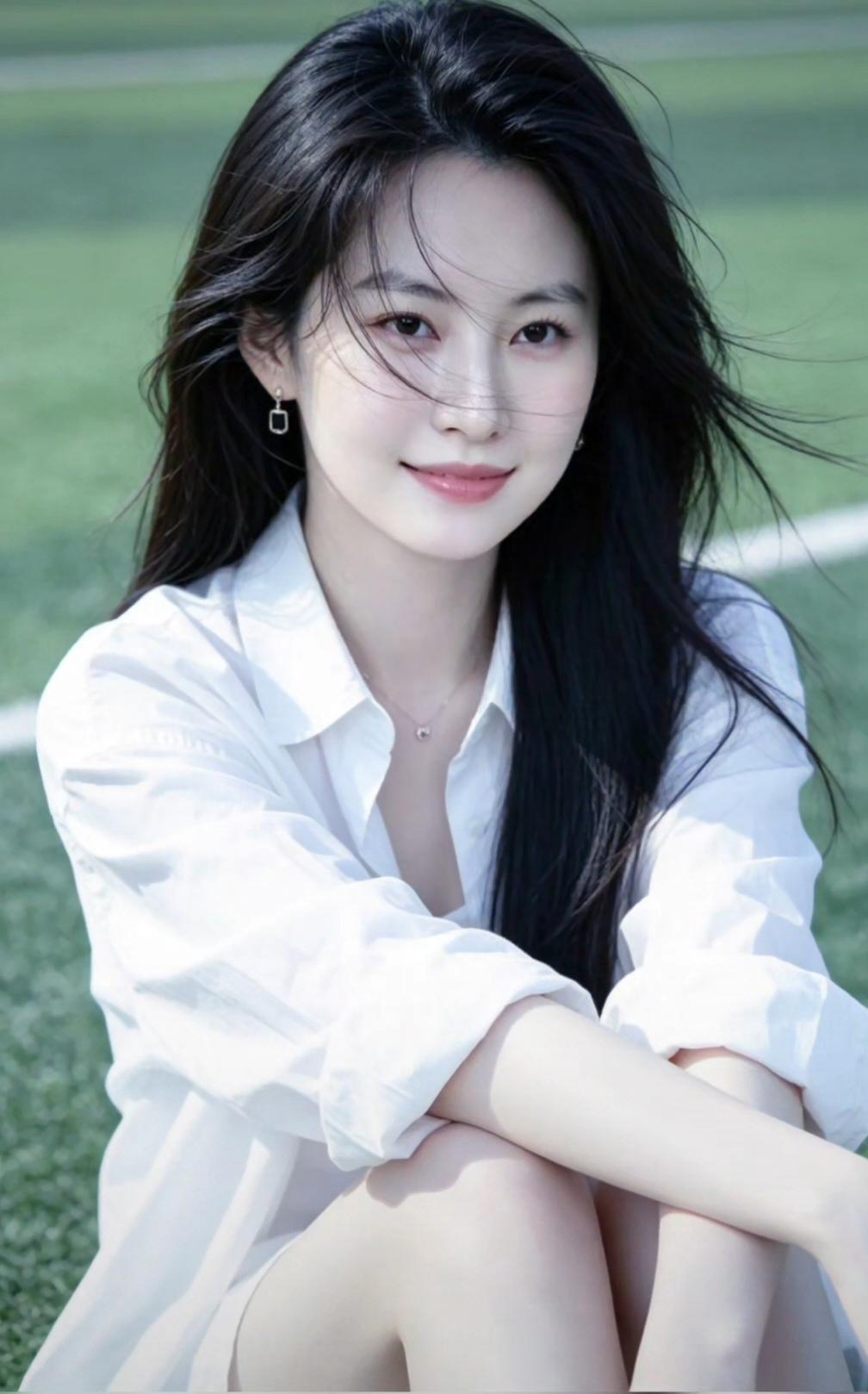 阳光明媚，她坐在草地上微笑。