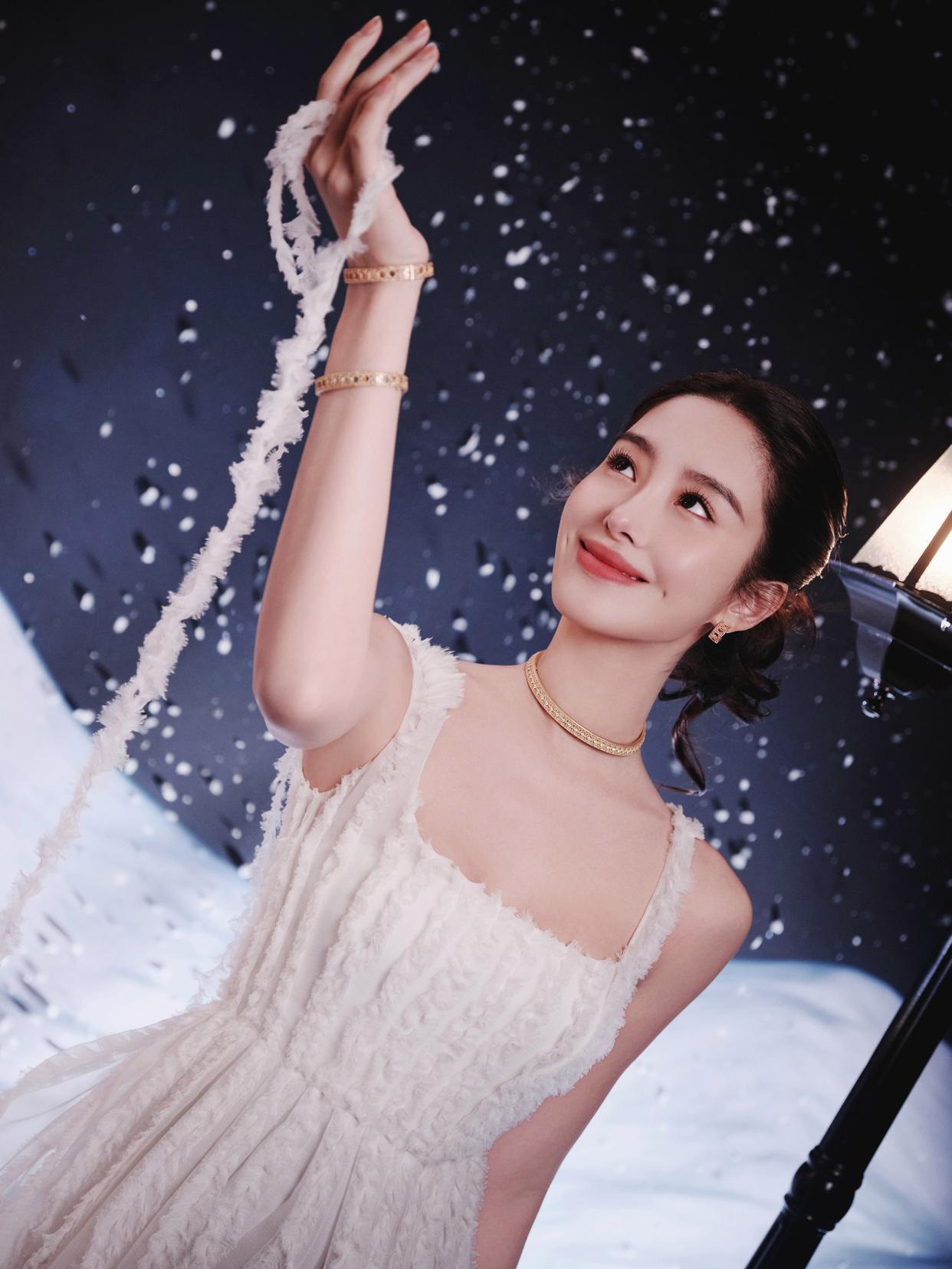 杨采钰一袭白色流苏吊带裙像裹了层月光，裙摆的细碎流苏随动作轻晃，衬得肩颈线条又柔