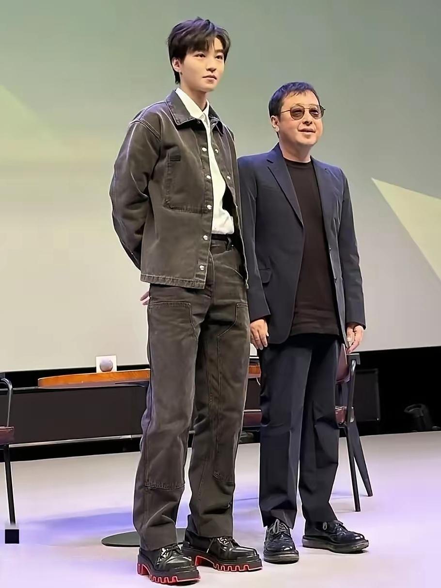 王俊凯与贾樟柯导演合影照，他个子高，身高182㎝，还穿个内增高的鞋，而且背着手，