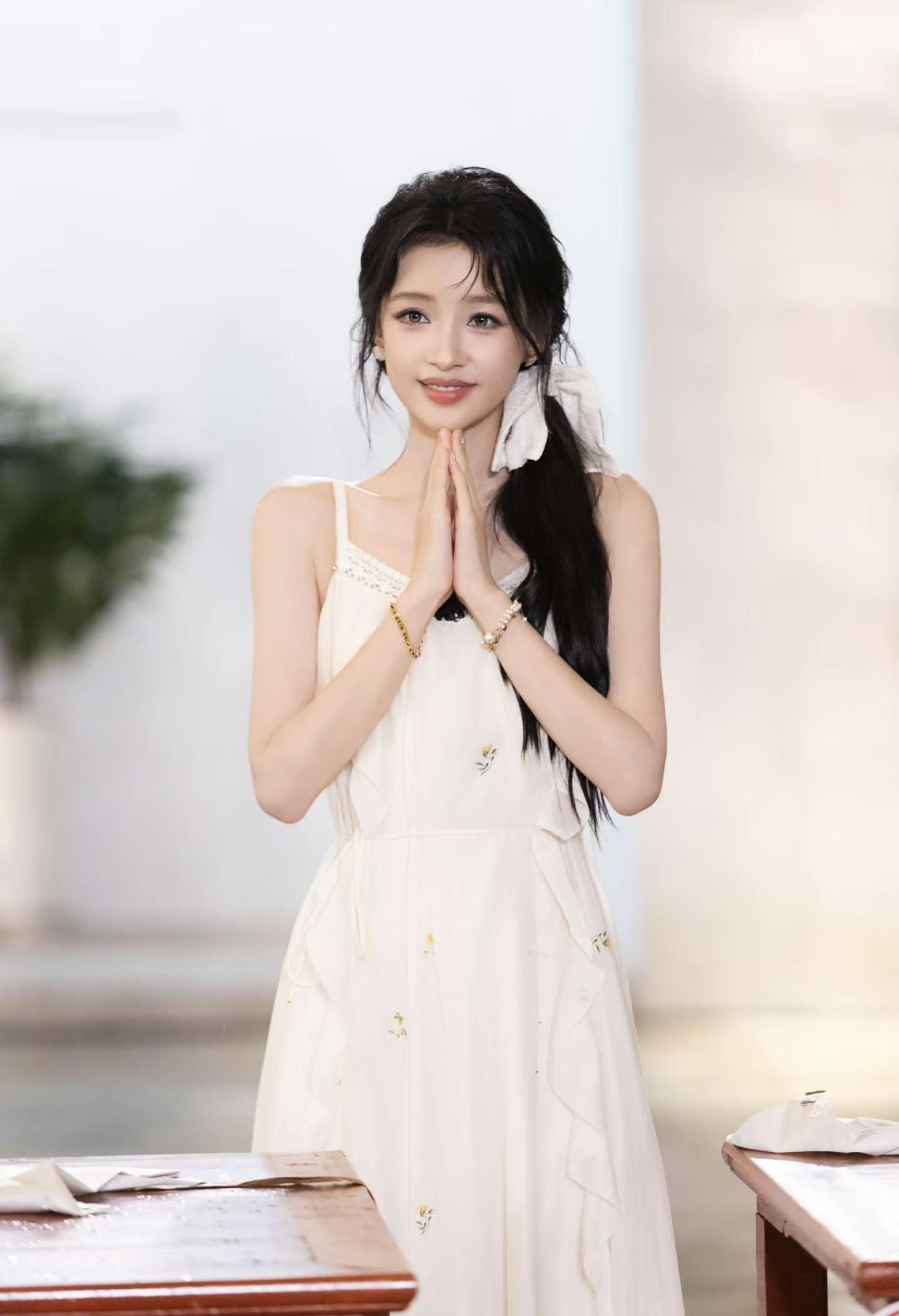 孙怡米白色刺绣碎花吊带长裙，面料干净柔和，裙身点缀小巧黄花刺绣，侧边荷叶边增添灵