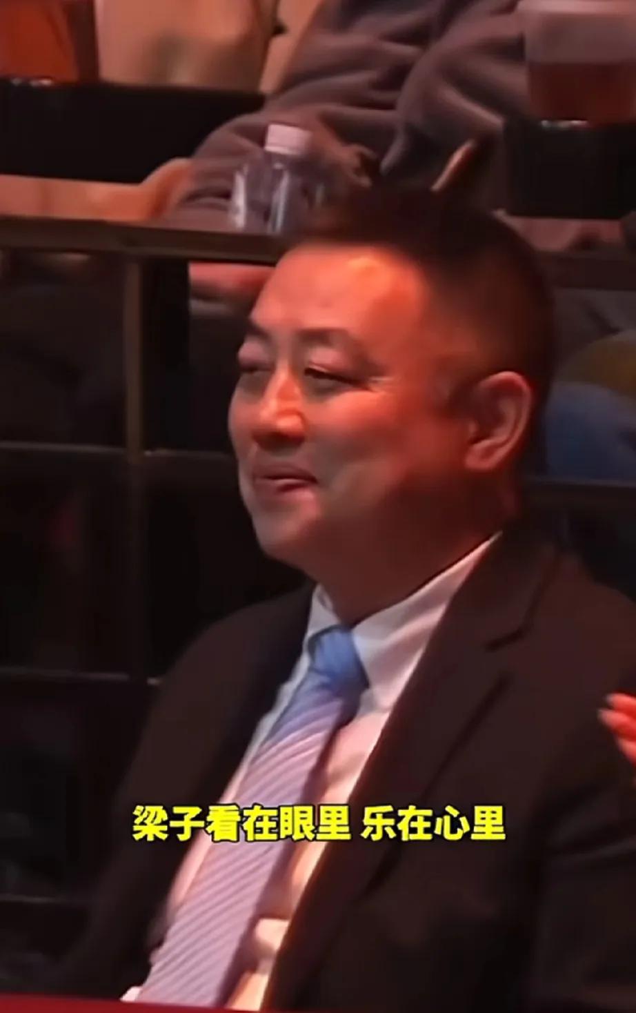 目睹孙颖莎与林诗栋荣耀登顶，场边的刘国梁教练难掩喜悦之情，嘴角不自觉地上扬，展现