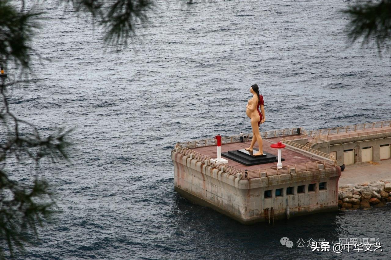 仔细看这是摩纳哥海洋博物馆百年庆典时设立的巨型青铜雕像，雕像是一位全裸的孕妇，她