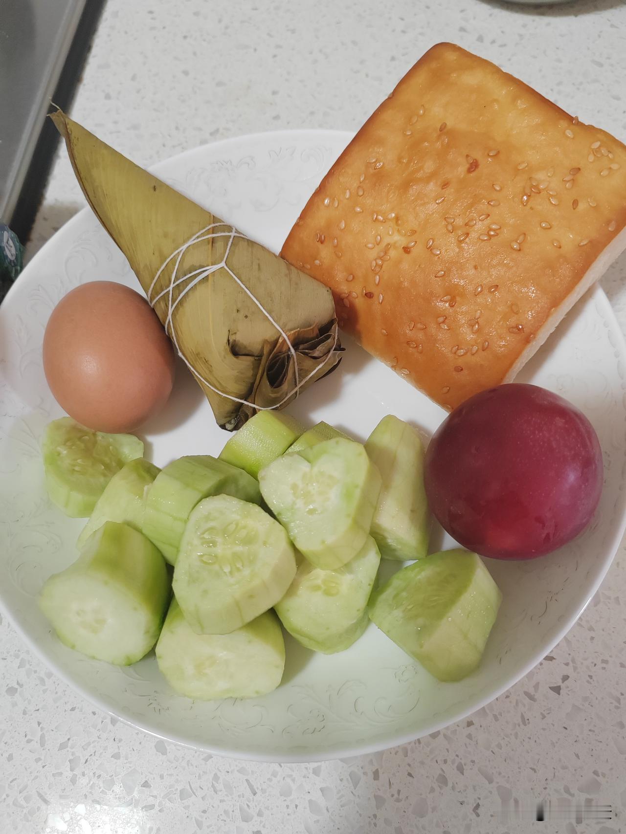 镜头下记录我的简单早餐，依旧一个水煮鸡蛋，一个豆沙甜粽，一块椒盐饼、一根黄瓜、一