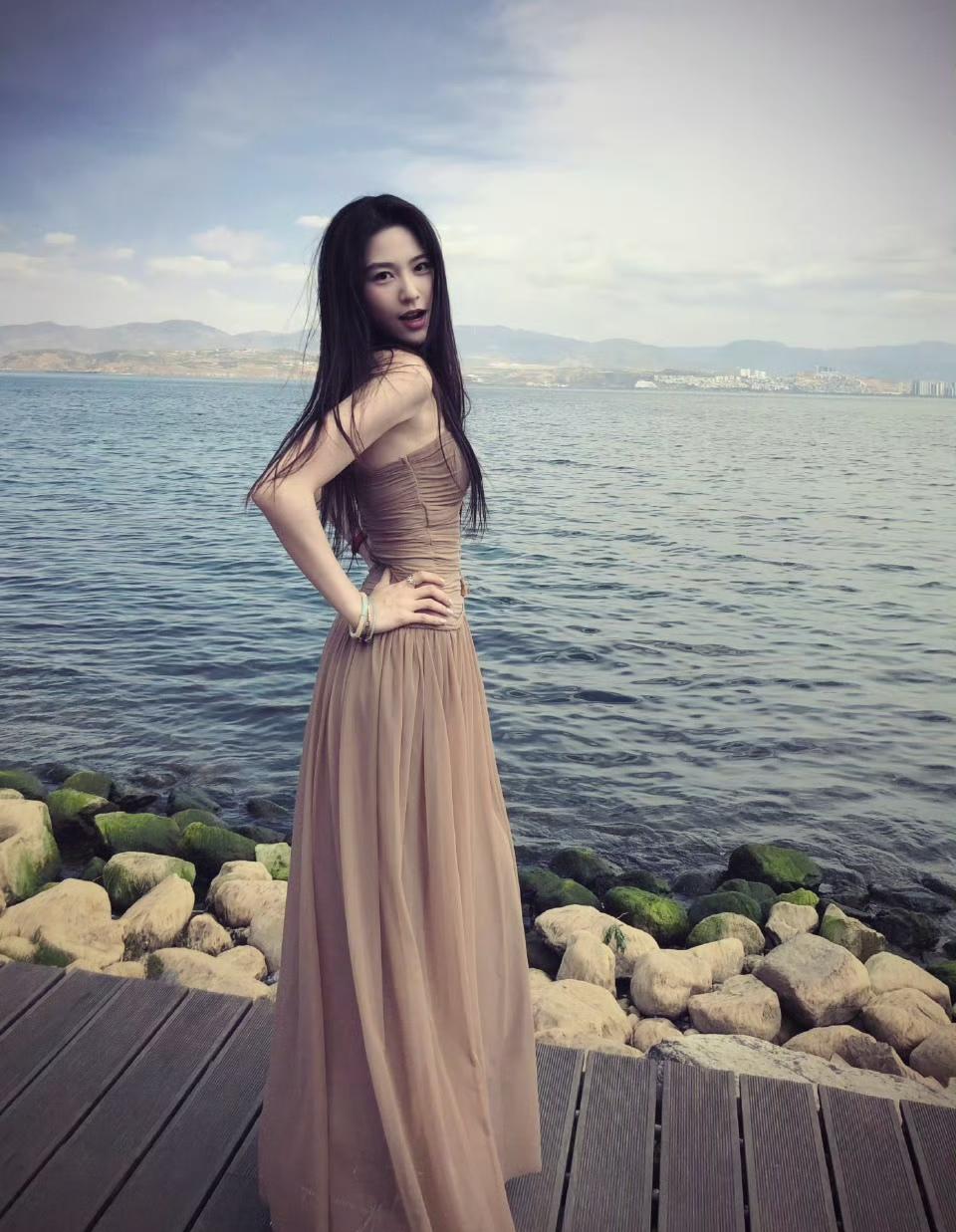 山海为幕，水波为诗，
一袭温柔裸色长裙，随风漫展的
长发漫过肩线，慵懒又明媚，