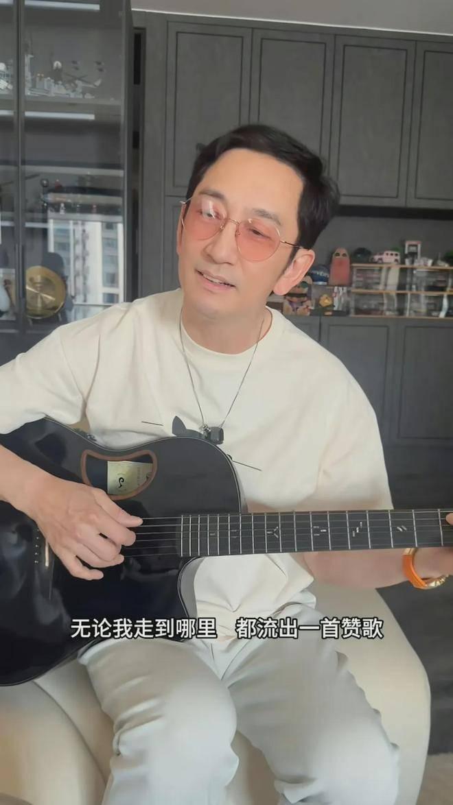 吴启华怀抱吉它自弹自唱
《我和我的祖国》不算专业演唱级，但感情真挚，很多观众觉得
