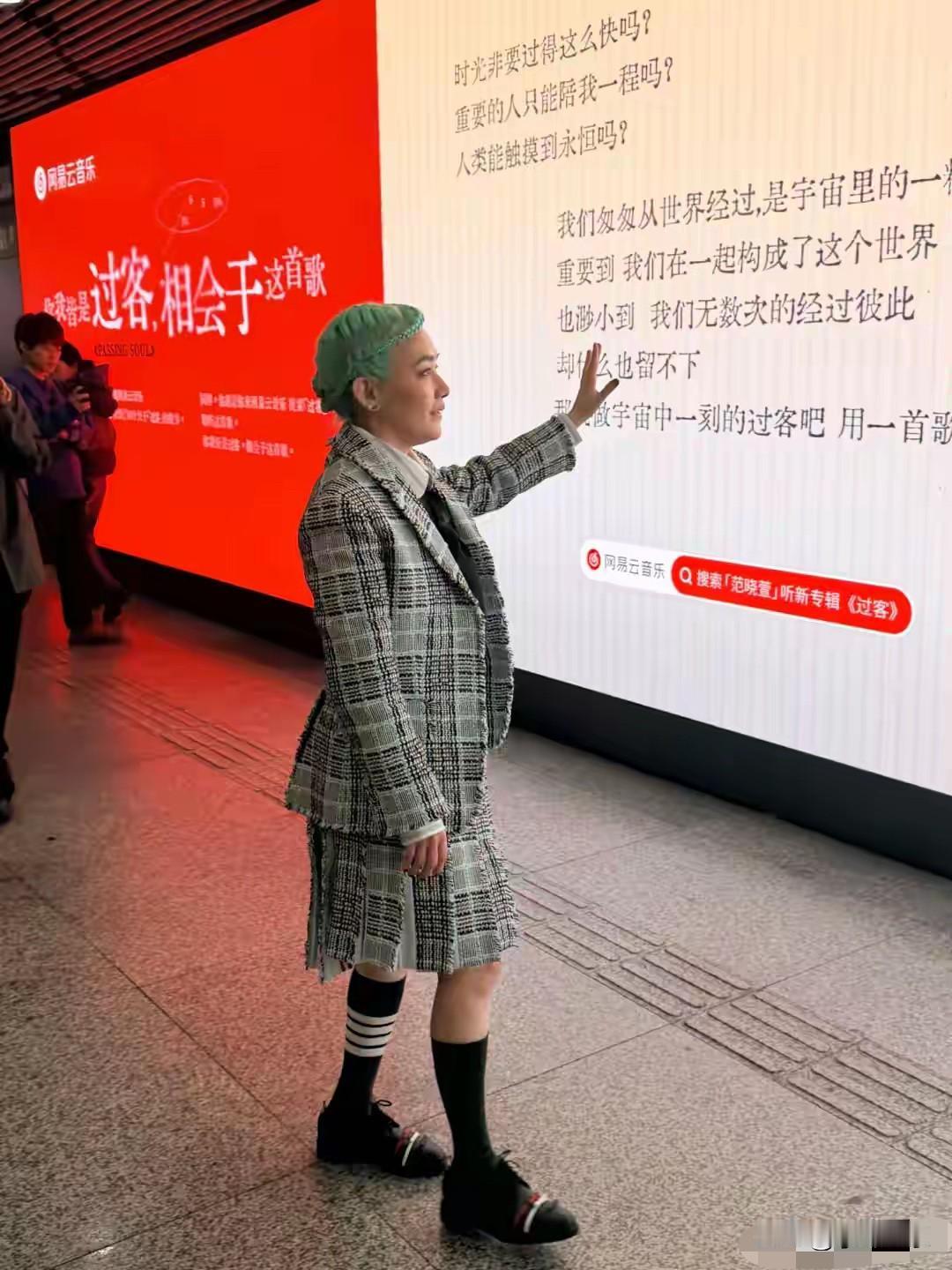 48岁的范晓萱在上海顶着一头翠绿短发，格外吸睛。她身着英伦风的格子套装，搭配黑色