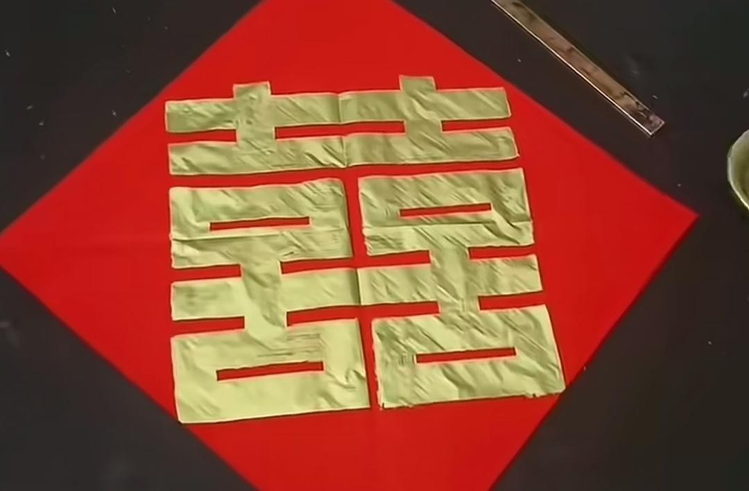 桌上的红色布上摆着绿色的“囍”字。今天有喜事降临，接住了吗？[作揖][玫瑰]