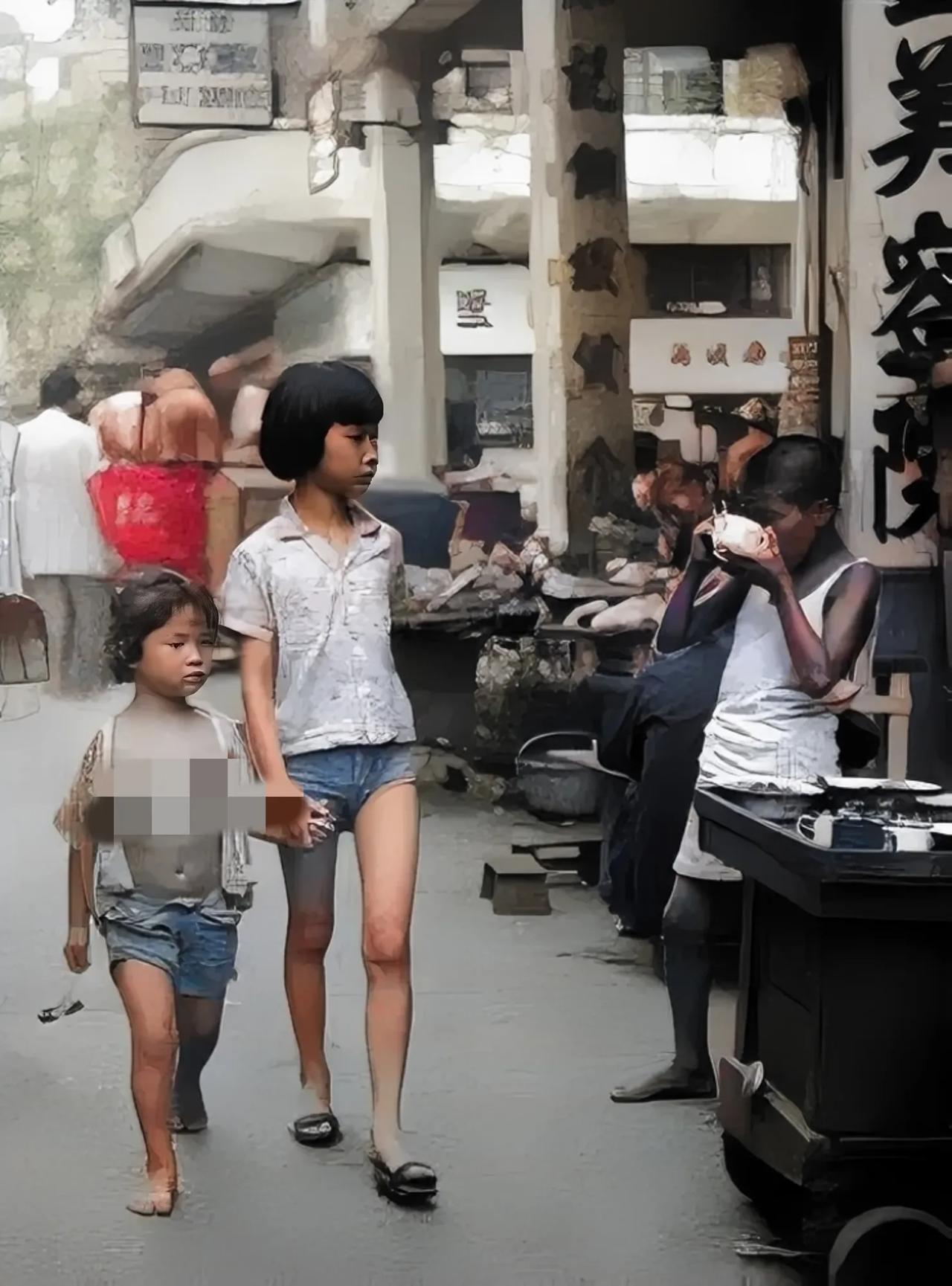 50年代初，香港街头，一个赤脚的小女孩正被姐姐拉着手，走过一家小吃摊。她看见一个
