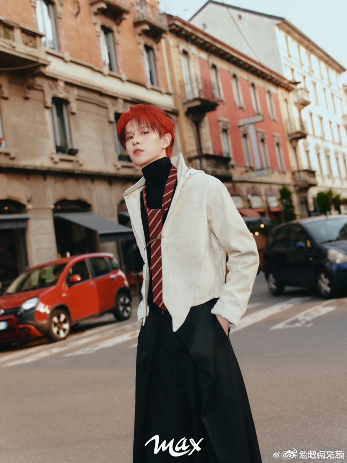 何浩楠意式街拍大片 蹲在湖边托腮，全黑西装衬得红发耀眼，意式水岸风光里，冷感与热