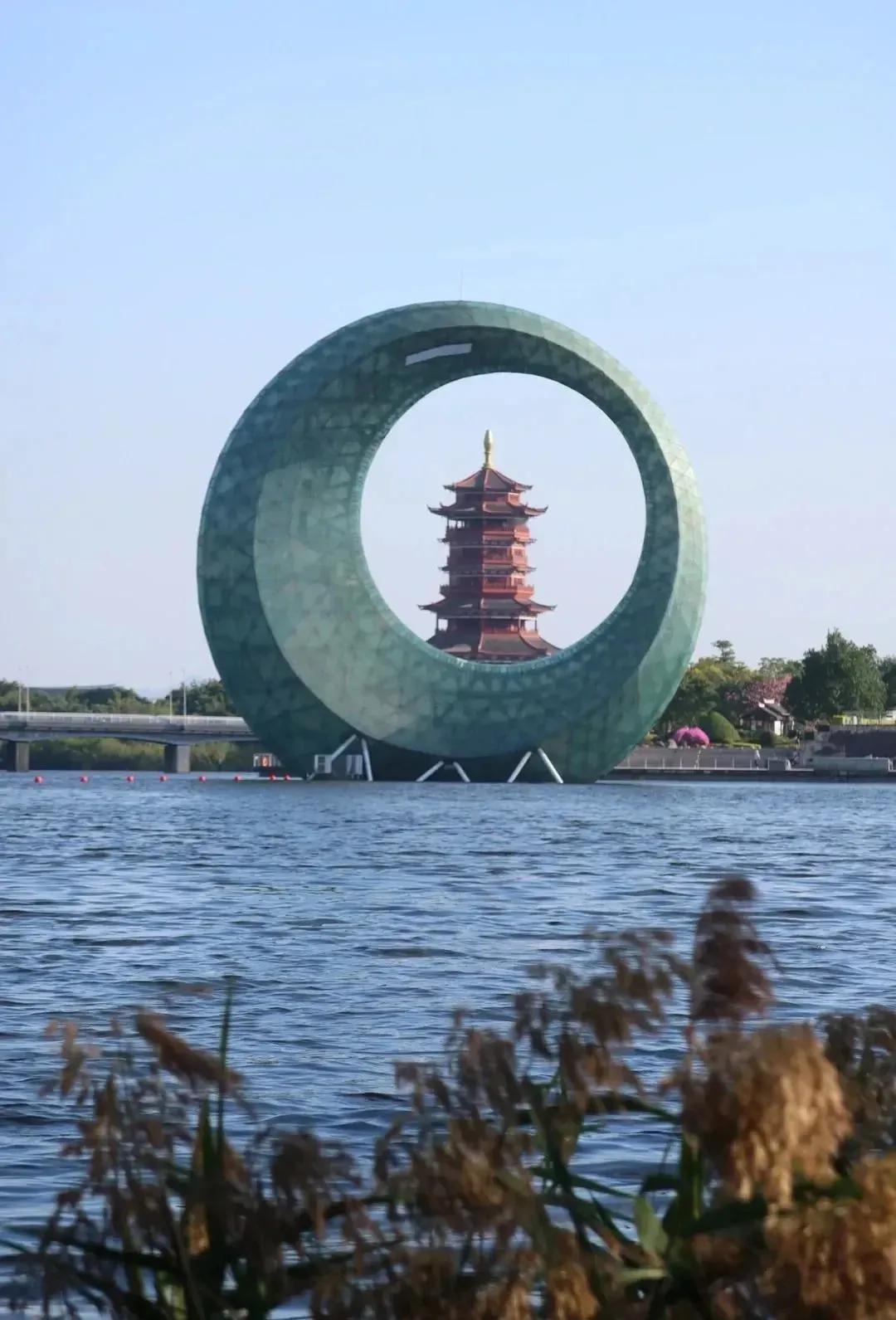 上联：古塔映衬现代环，湖畔风景美如画。
下联：[爆竹][爆竹][爆竹][爆竹][
