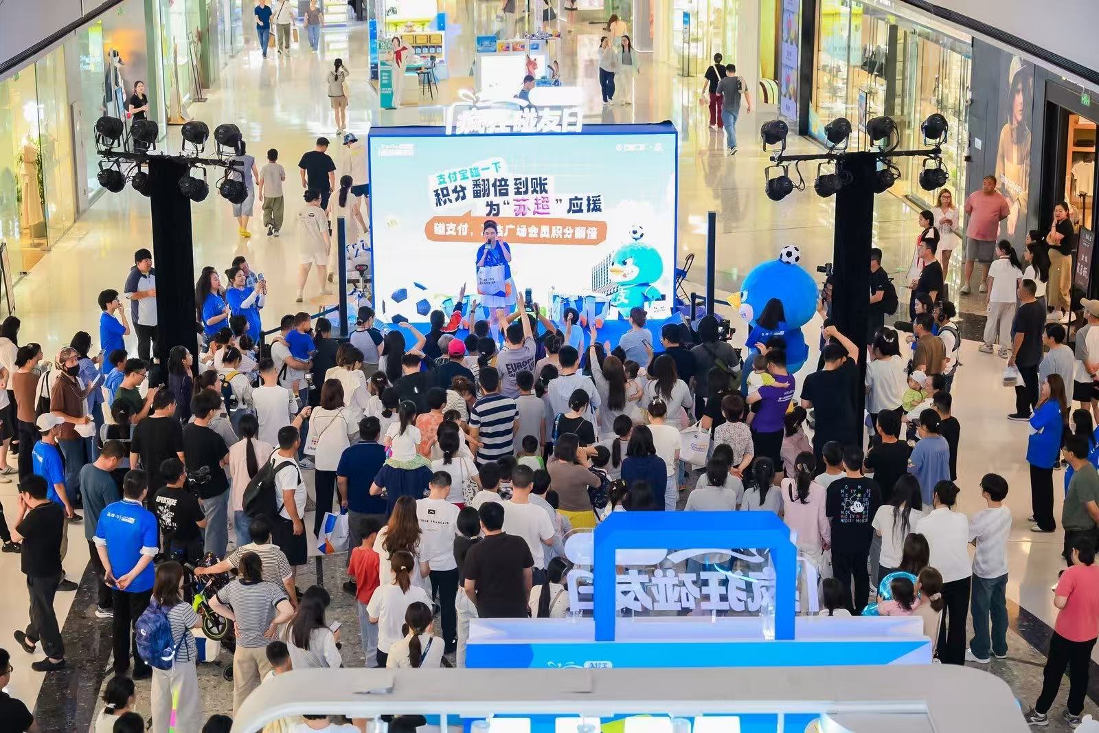 百店发支付宝助威袋为南京队加油来万达广场解锁苏超趣味应援，恰逢万人应援气球雨空降