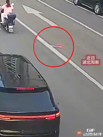 湖北黄石阳新一处街头，一个女孩放学回家时，看见马路中间有一面小国旗，于是她当即走