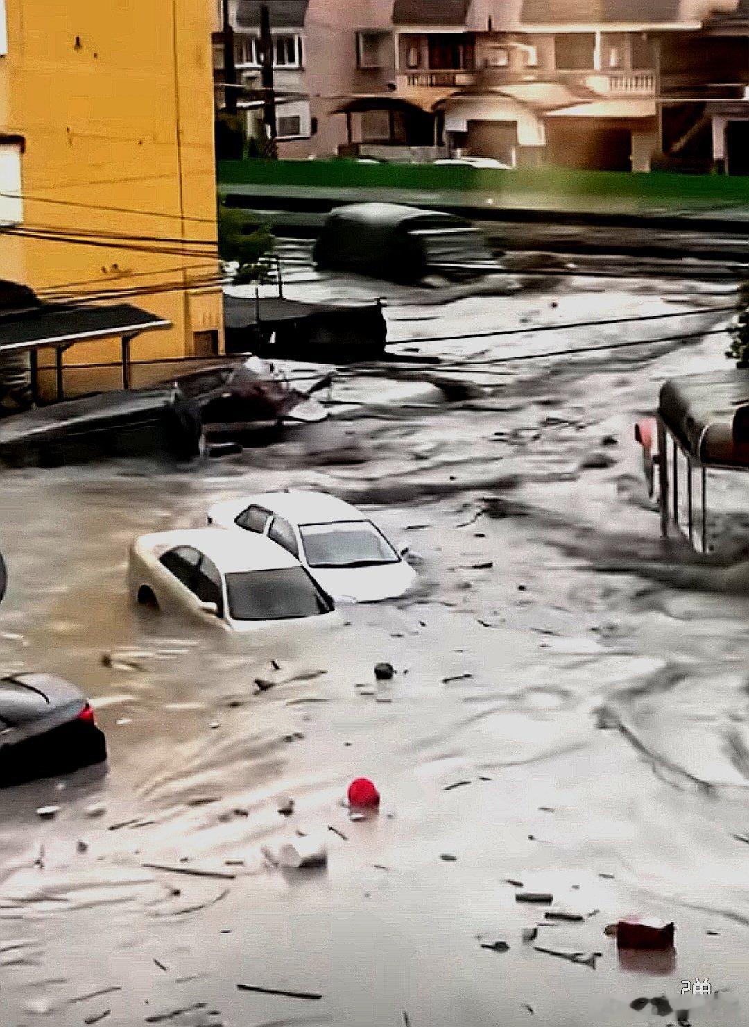 中国大陆某地的暴雨洪水冲走了路边的汽车 