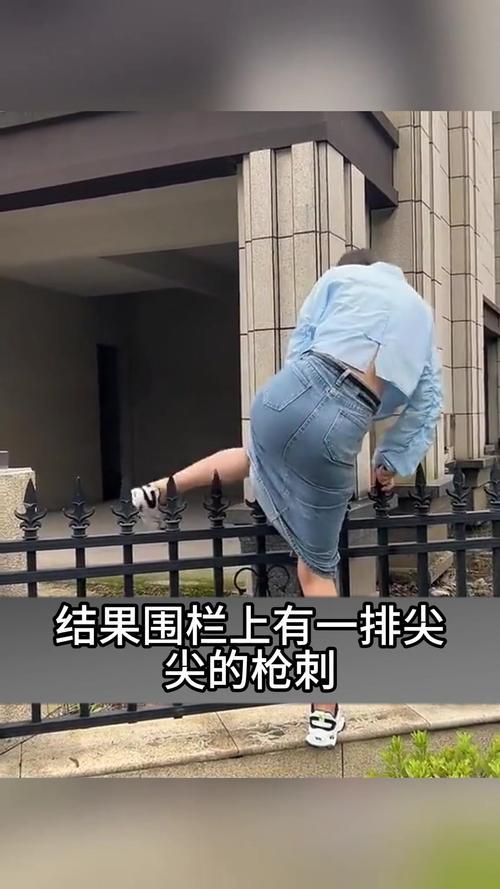 街头女子为拍氛围感照片，侧身钻护栏时裙摆不慎勾住栏杆，进退不得卡得满脸通红。路人