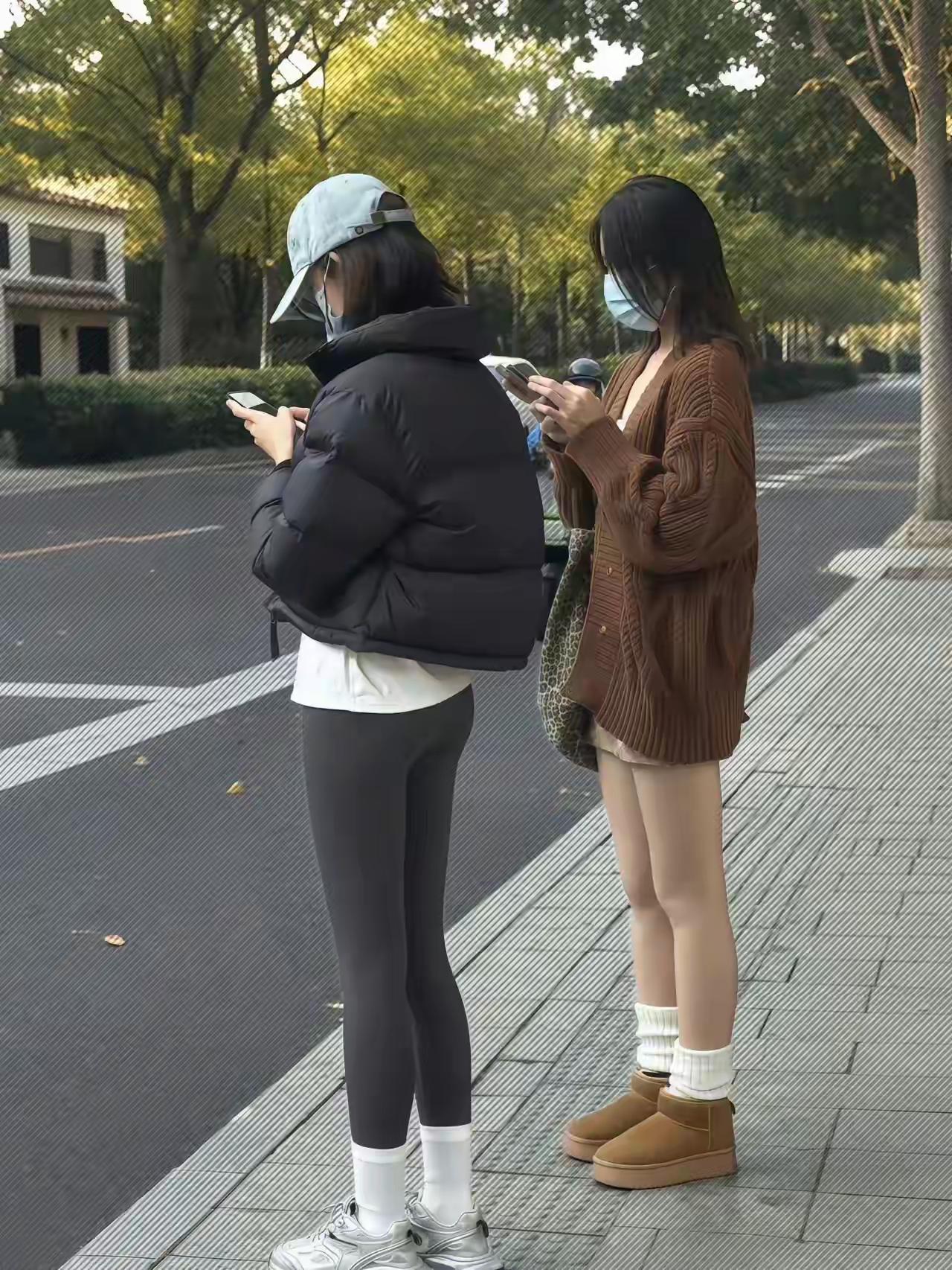秋风起，落叶飞，两女共赏手机时。