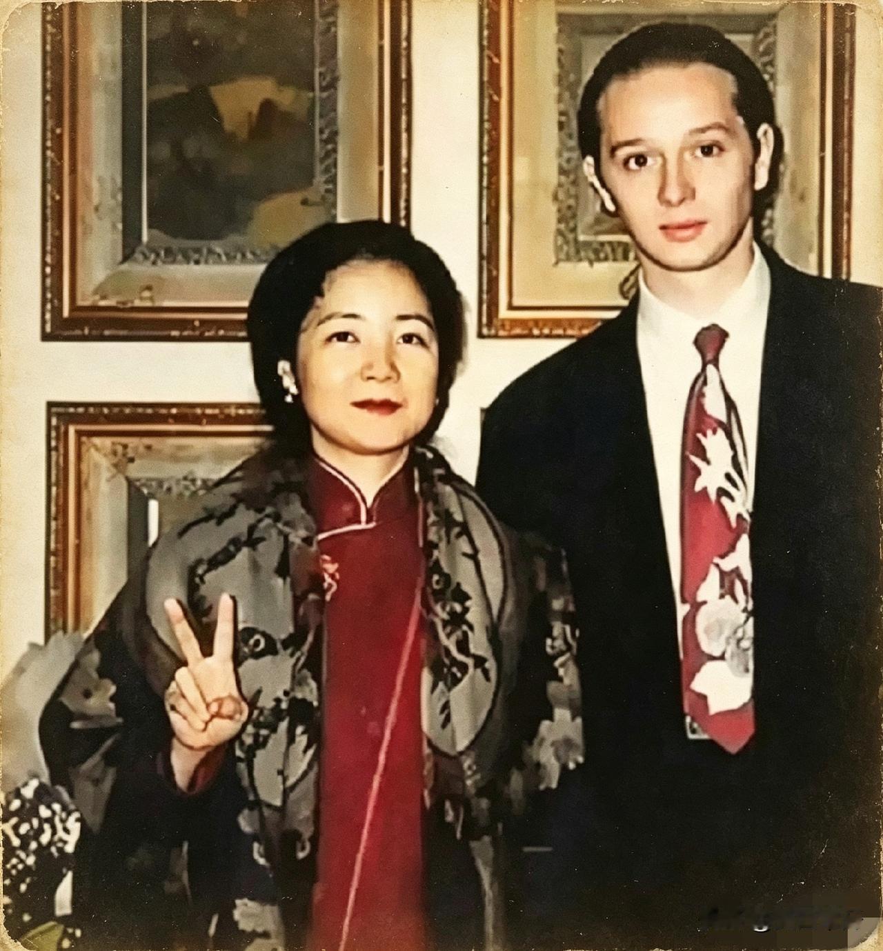 邓丽君身着中式衣衫，比出剪刀手，身旁站着帅气男友，邓丽君神态松弛，嘴角藏着浅浅笑