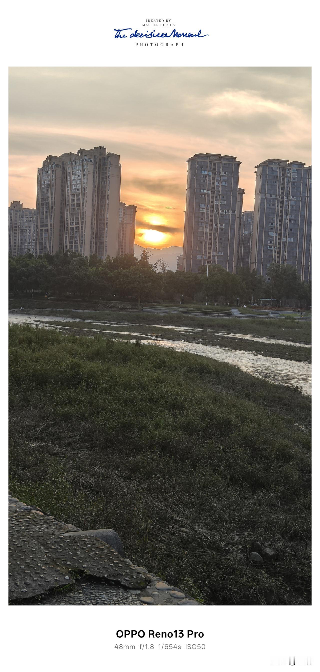 傍晚六点，站在河边邂逅一场温柔日落。夕阳悬在楼宇与远山之间，金灿灿的光芒铺洒开来