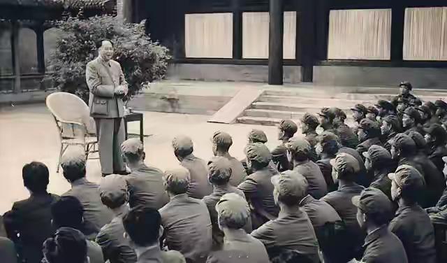 1956年，毛主席站在庭院中，面对一群身着军装的警卫战士亲切地讲话。没有讲台，没