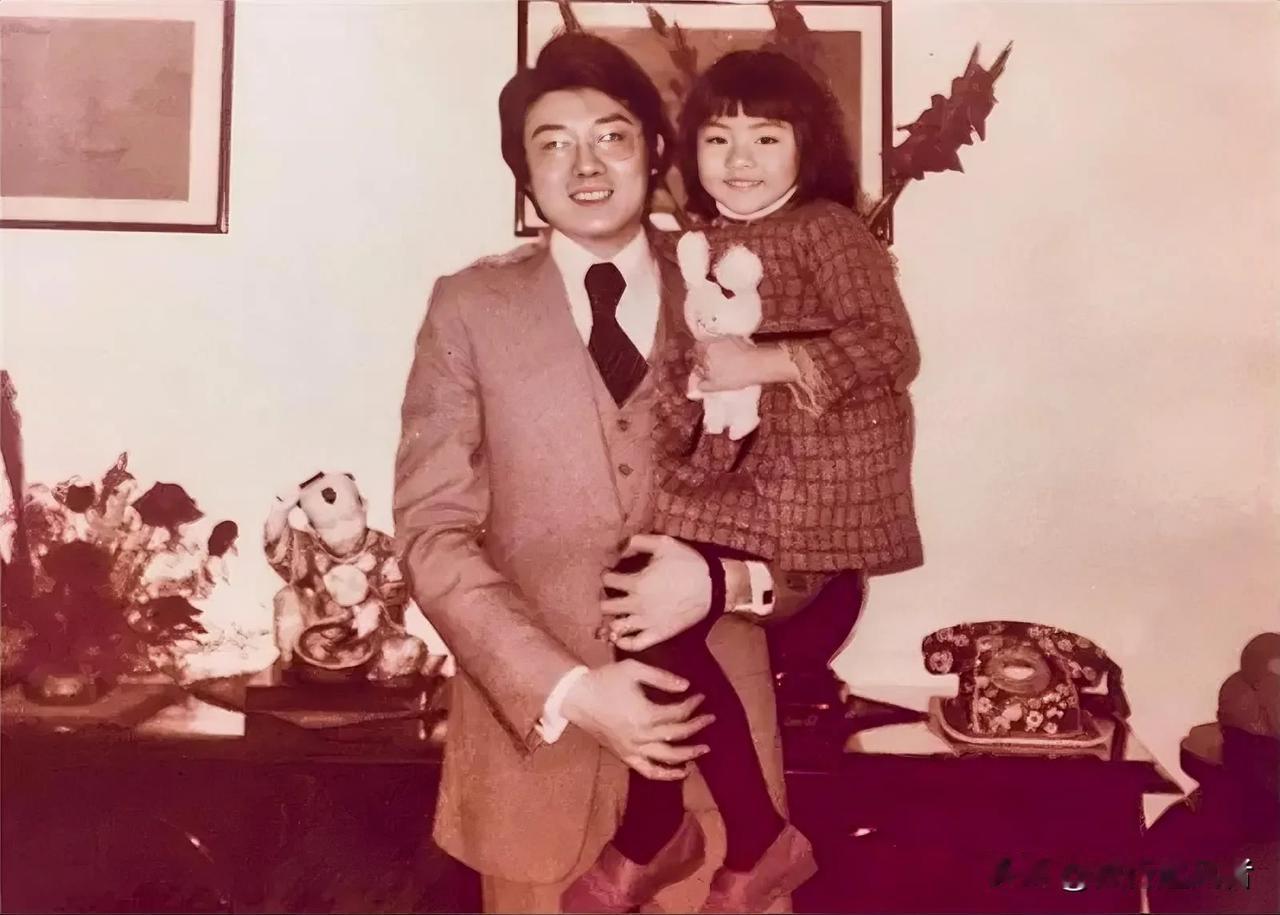 这张照片拍摄于上世纪70年代末的中国香港，是一位父亲抱着女儿在家中的合影。
从房